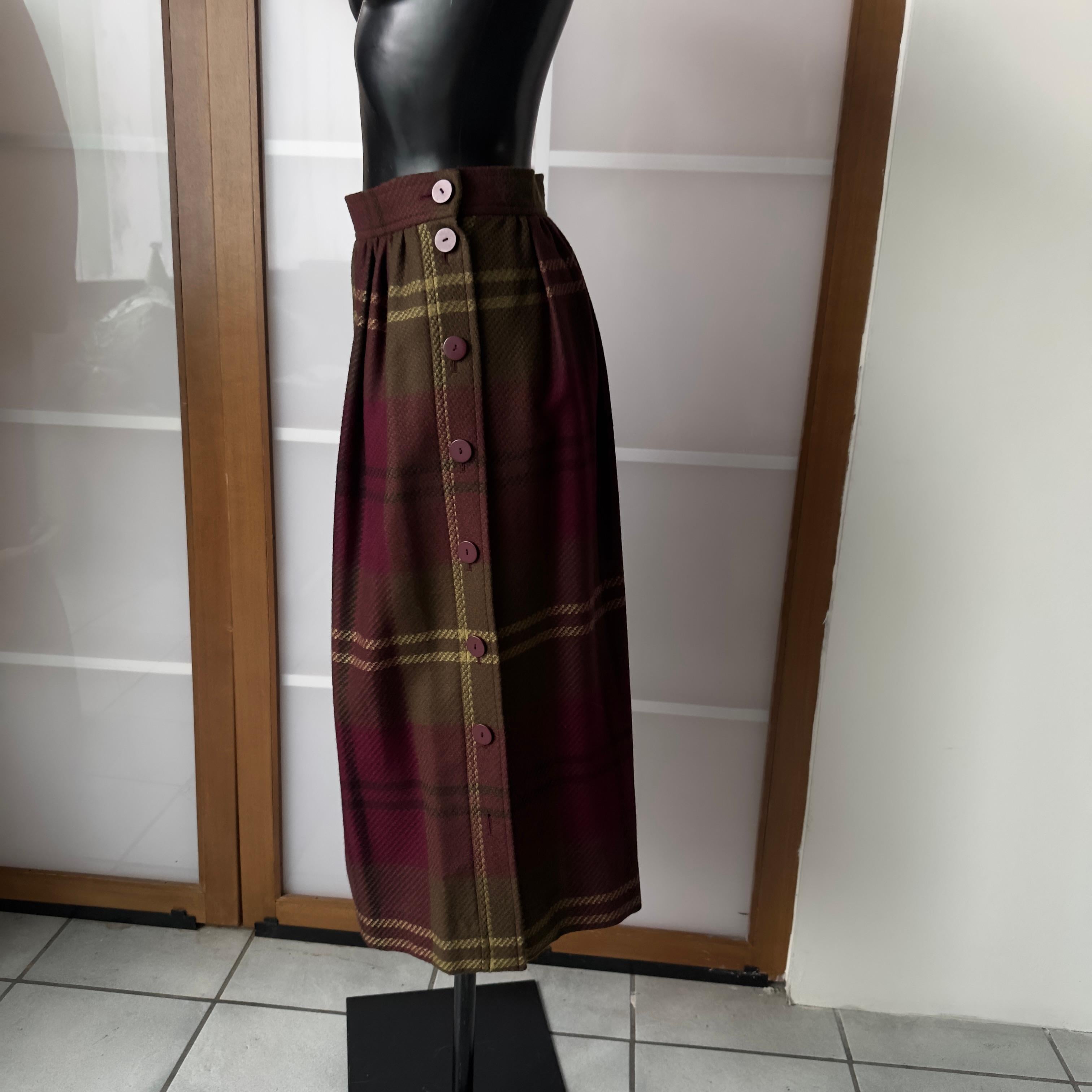 Gonna midi Yves Saint Laurent anni 80
Fantasia tartan sui toni del verde e viola, chiusura con bottoni laterali
Tasca lato destro, composizione lana
Nuova mai utilizzata
Misure:
Vita 34cm
Lunghezza 75cm