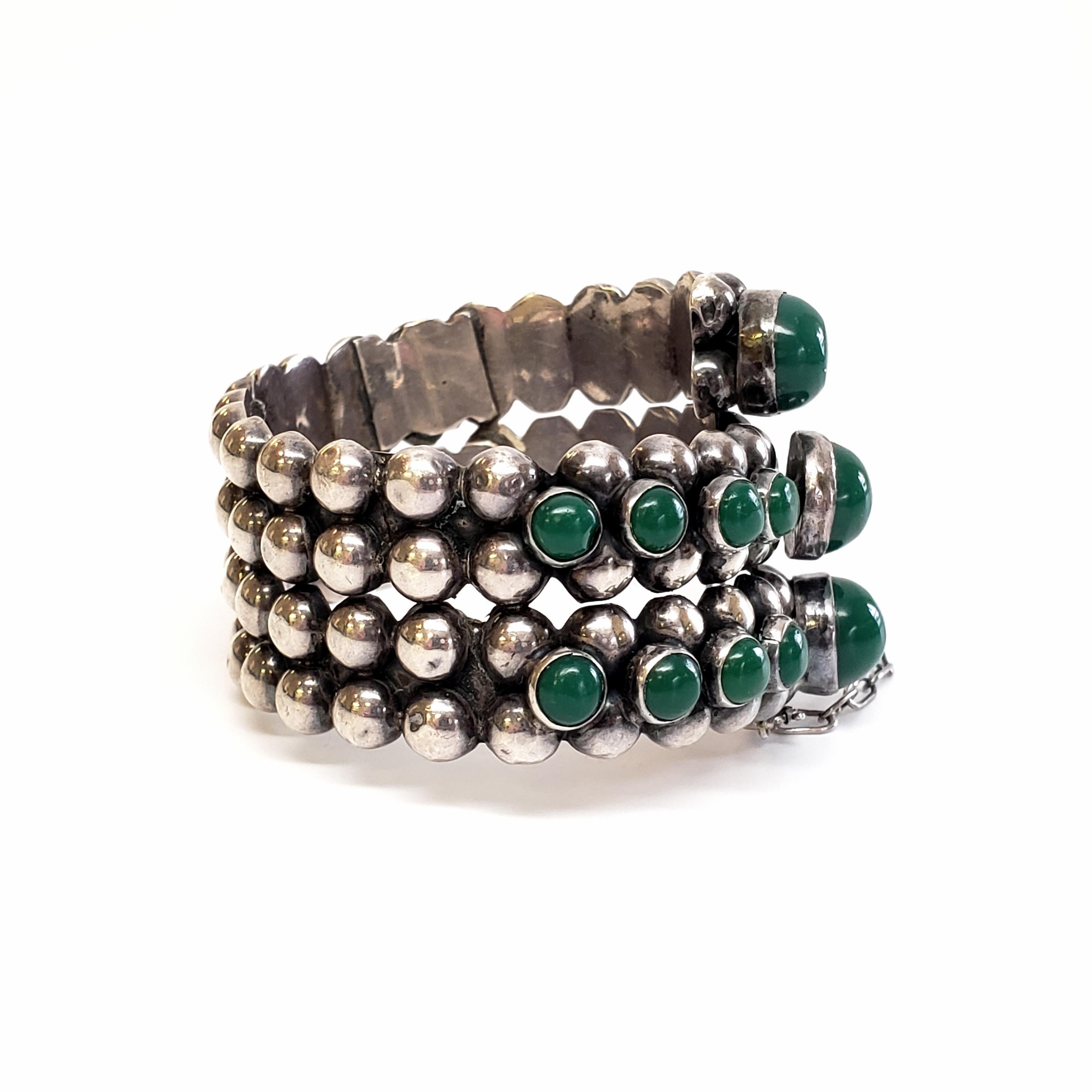 Vintage Taxco, Mexico Sterling Silver and green onyx hinged bracelet.

Beautiful silver bracelet by renowned master silversmith, Gonzalo Moreno. The traditional style bracelet features a beaded design and round, bezel-set green onyx stones. Slide