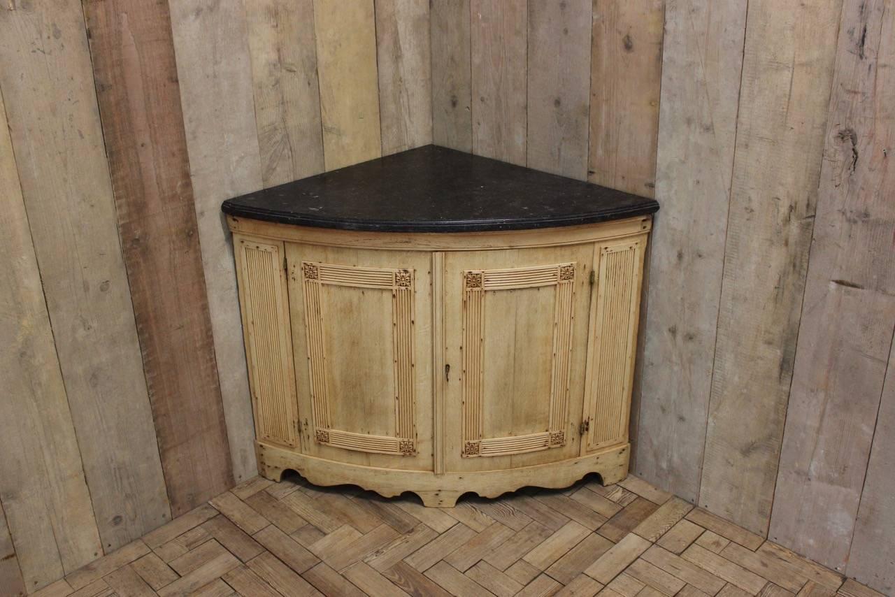 A very elegant 19th century corner cupboard in bleached oak, in the classical taste, retaining the original marble top, that will work well in most settings.
      