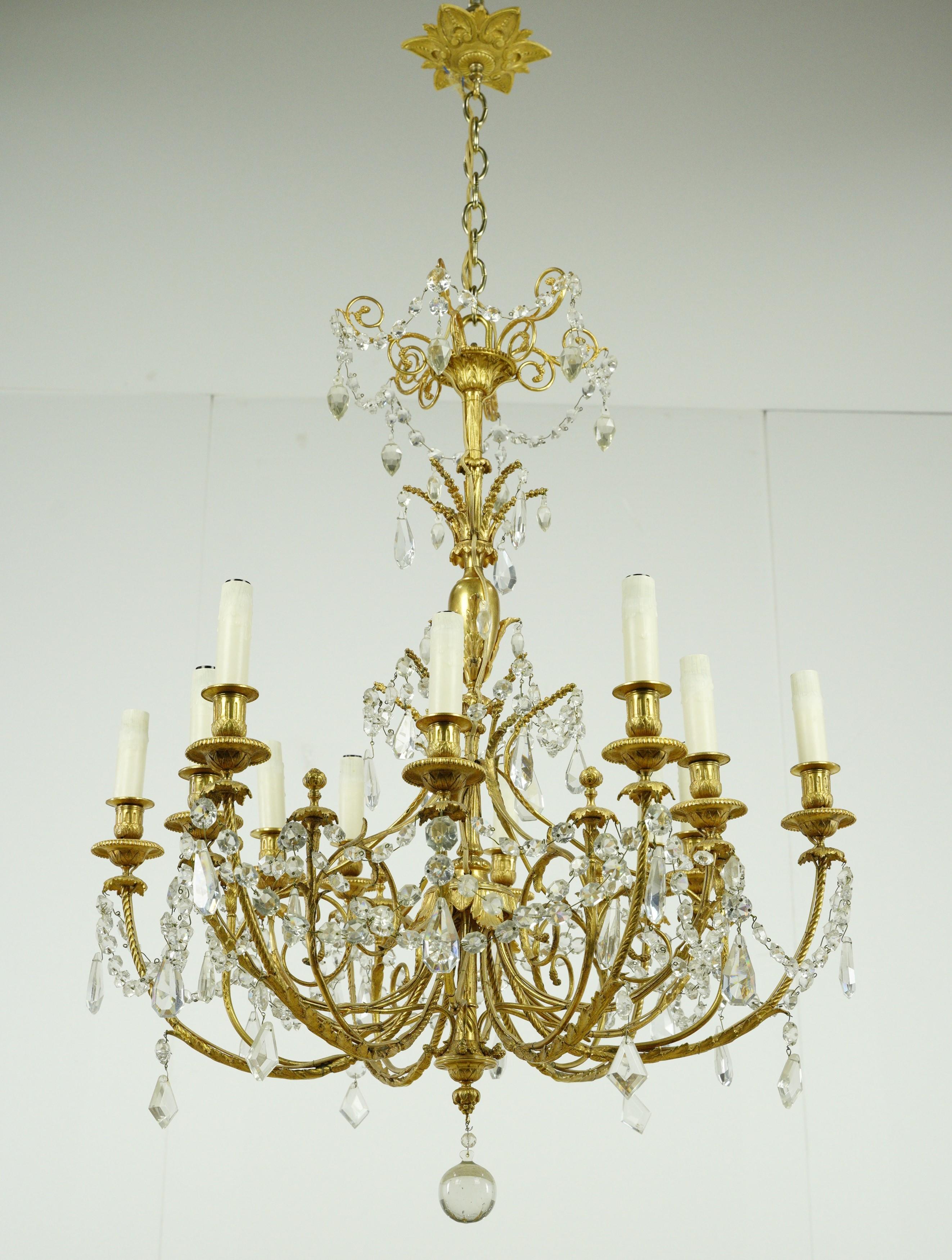 This resplendent piece features an intricately designed gold-plated frame, exuding ornate craftsmanship that enhances its overall aesthetic. Clear crystals gracefully drape throughout the chandelier, adding a touch of opulence and brilliance to its