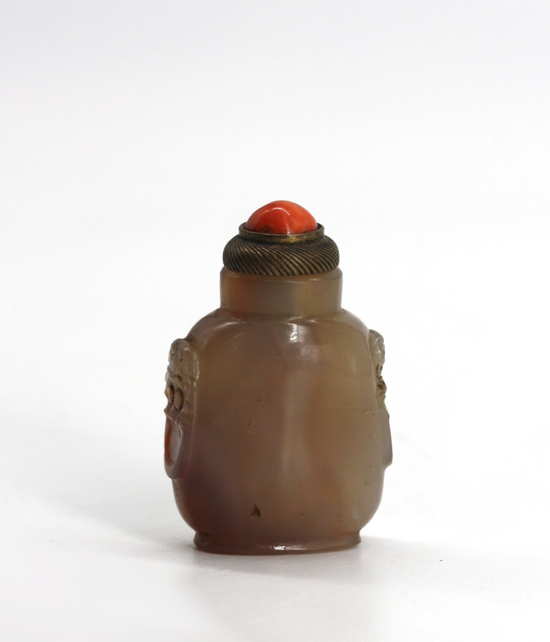 
Bouteille à priser en agate chinoise
Le corps rectangulaire façonné avec des marbrures rousses à grises et claires, les côtés avec un masque aplati et des poignées en anneau, sur un pied surélevé, avec un capuchon en métal serti d'un cabochon, avec