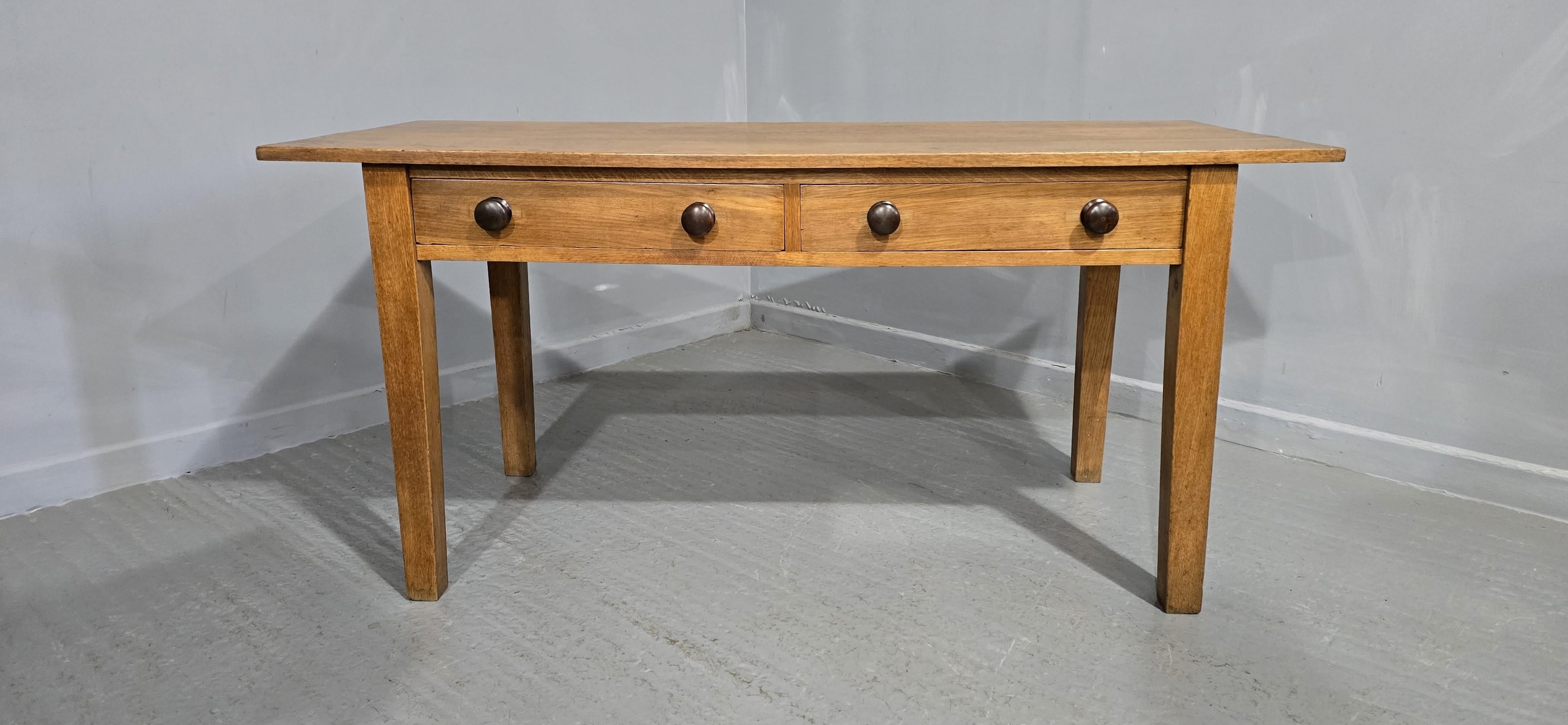 A very nice golden oak three plank dining table with two drawers, standing on tapered legs, good overhang each end, turned knobs, in excellent cleaned and waxed condition.

30