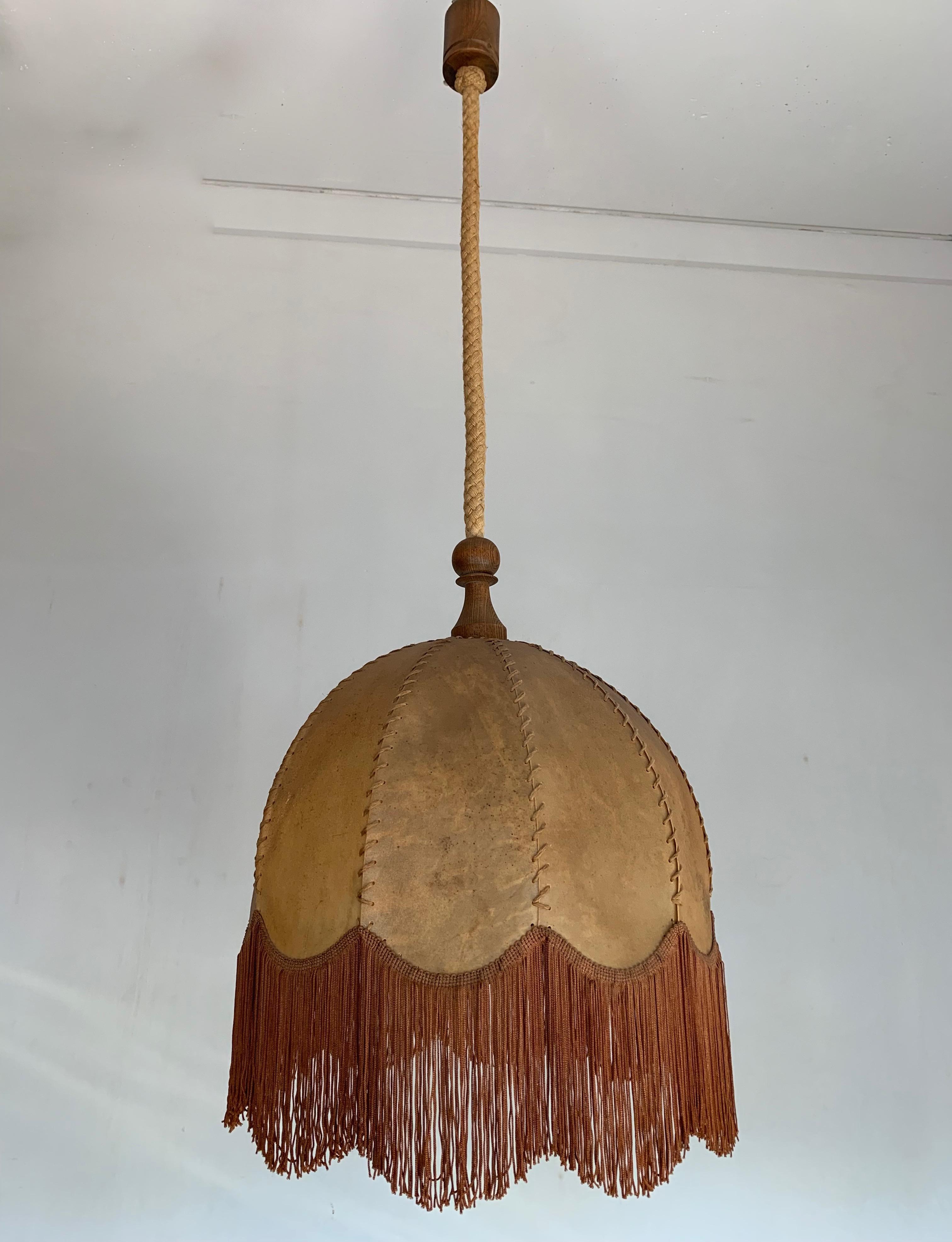 Beautiful shape and excellent condition pendant.

This early 20th century leather pendant comes with the original rope and ceiling cap. The shape, the color and the effect of the light shining through the natural hide make this pendant a real joy to