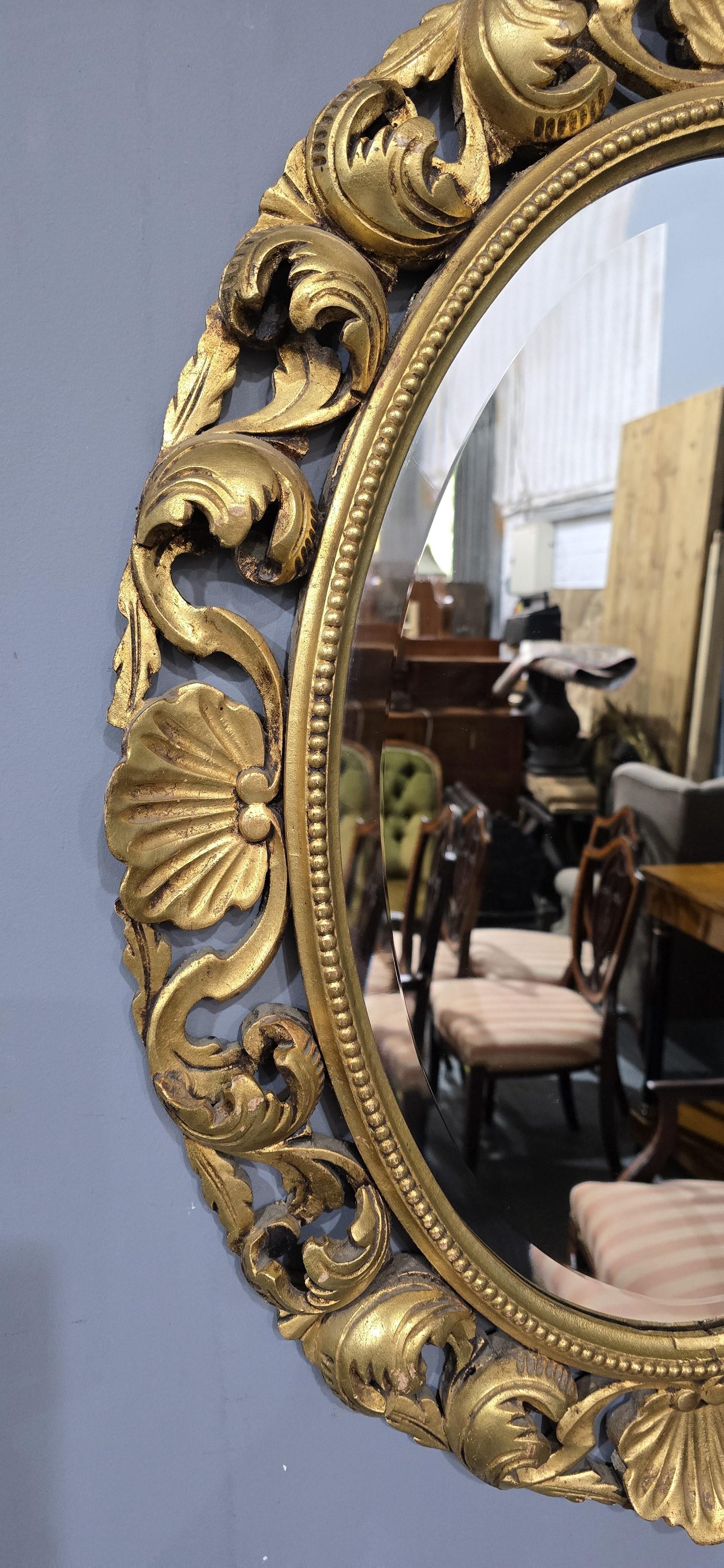 Oval gilt wall mirror with deep undercut carving, original beveled mirror, in very good condition, can be hung portrait or landscape.

32