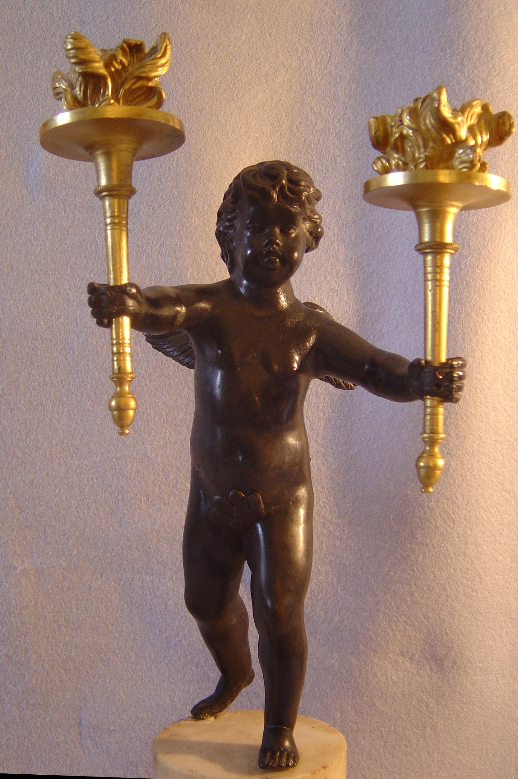 Ein gutes Paar englischer Regency-Figurenkandelaber aus weißem Carrera-Marmor, patinierter Bronze und Ormolu. Jedes hervorragend gegossene und bearbeitete Kind hält in jeder Hand einen Kerzenhalter aus Ormolu, der als Fackel dekoriert ist. Jede