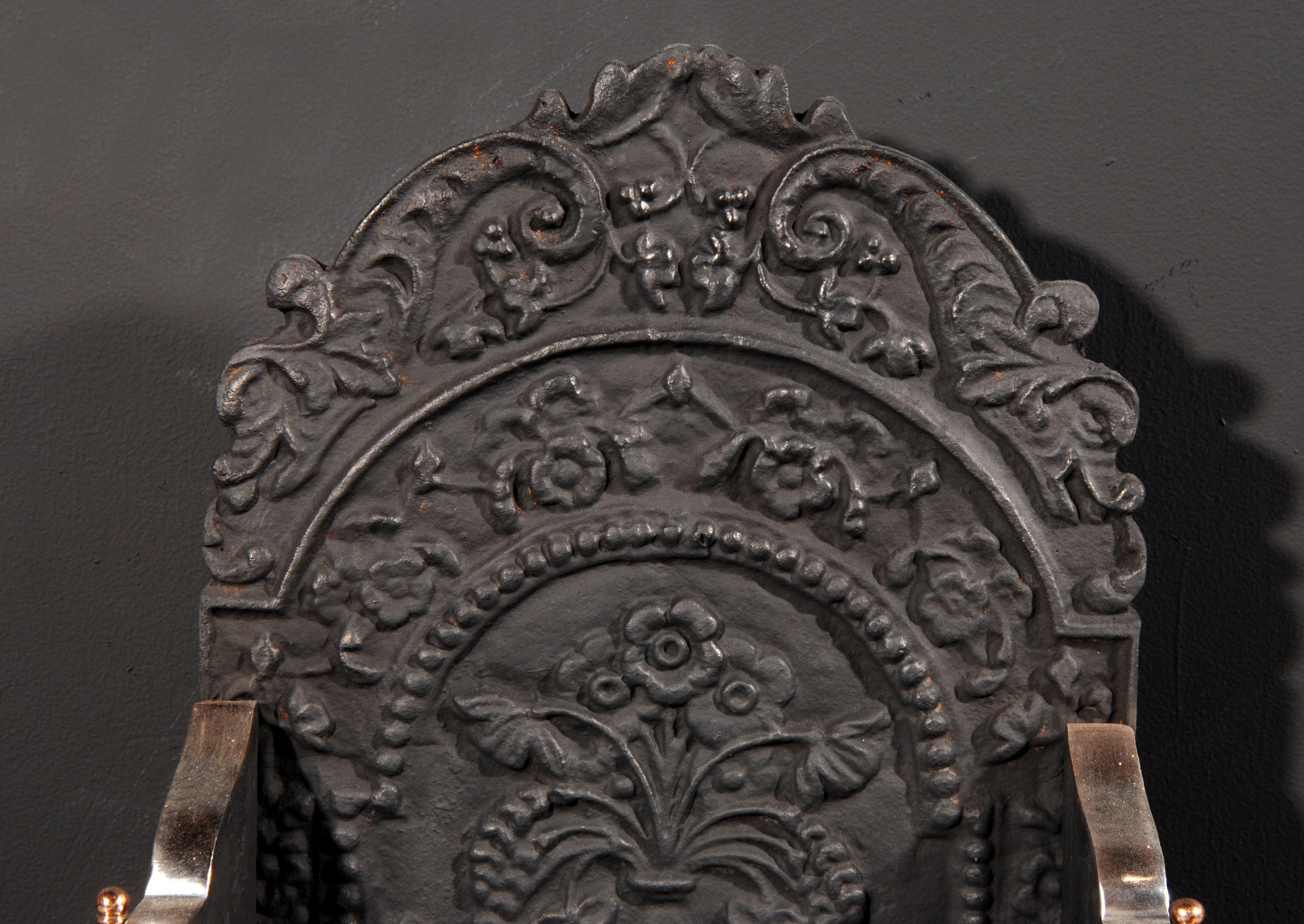Fine quality Georgian style dog-grate in unusual enriched gunmetal, with engraved paterae to fluted fret, and engraved legs and wings. Cast shaped decorative back of floral design, early 20th century. In the manner of Thomas Elsley.

Measures: Width