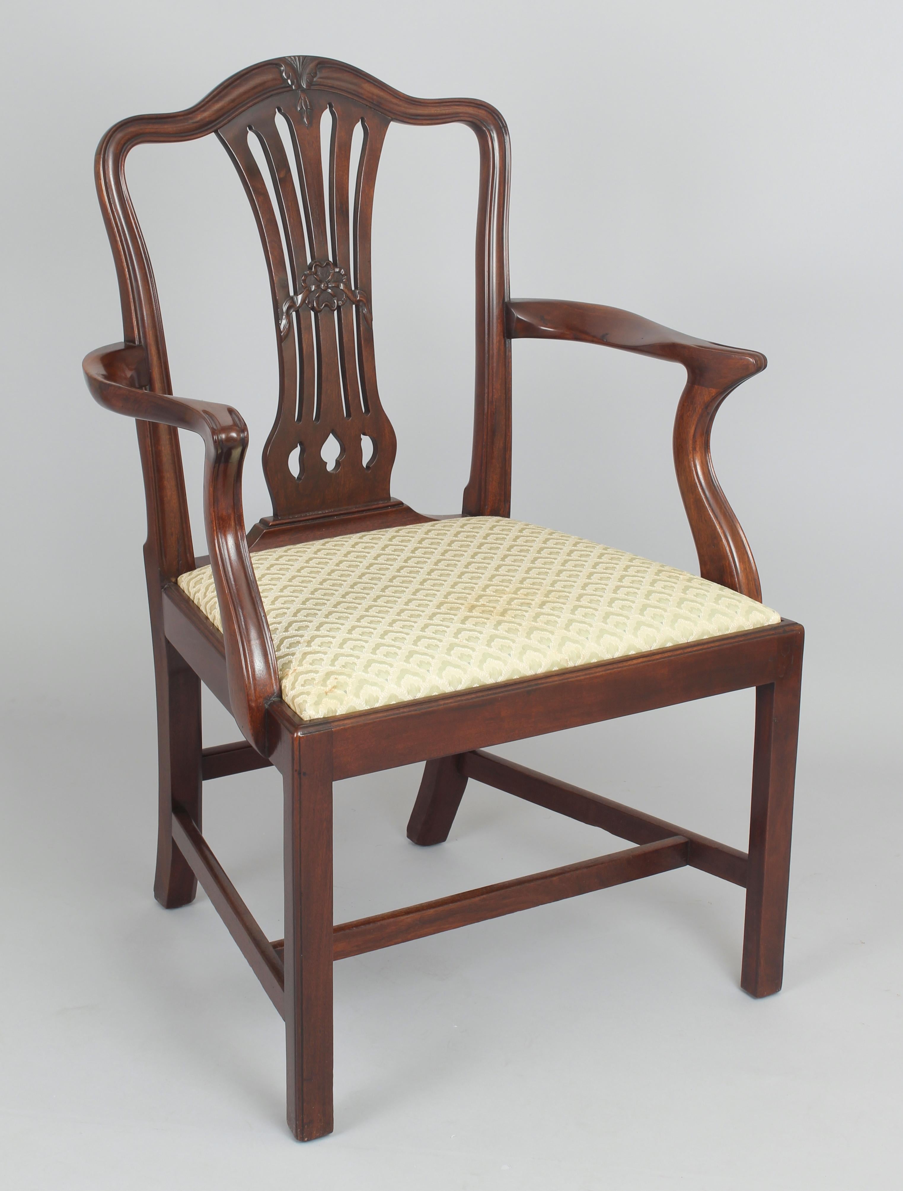 A good quality set of eight mahogany dining-chairs in the Hepplewhite style; the backs with serpentine tops and openwork splats with carved ribbon decoration; the loose seats covered in beige fabric and on square legs with stretchers. Six