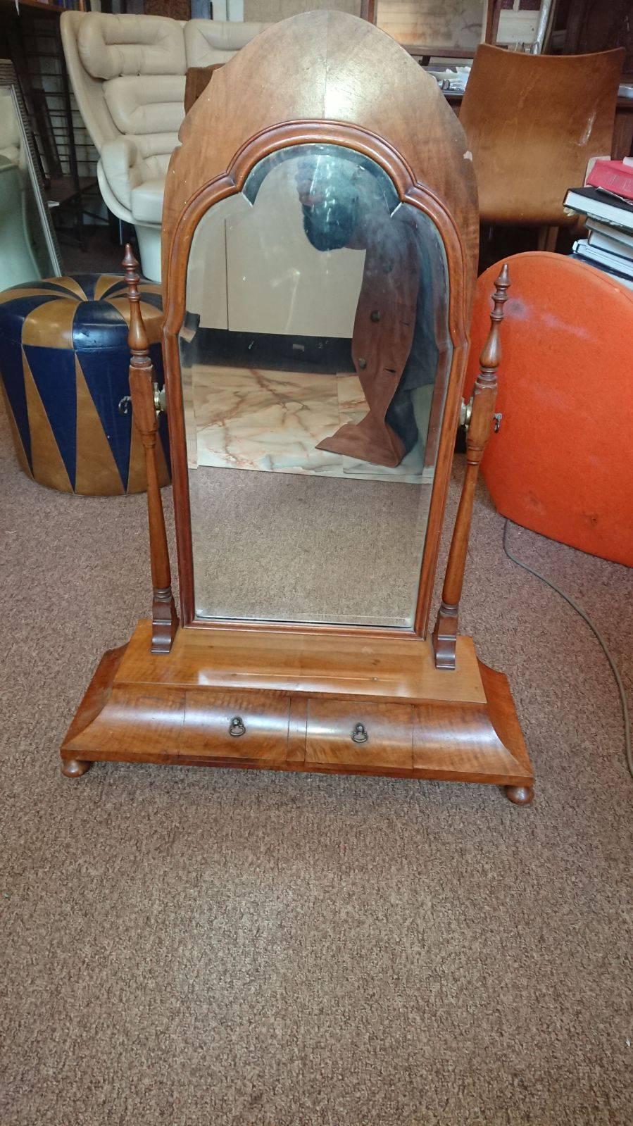 A good quality walnut dressing table mirror in the style of Sir Robert Lorimer with turned supports and a large shaped bevelled mirror with shaped base and a pair of Jewellery drawers, on bun feet.
  