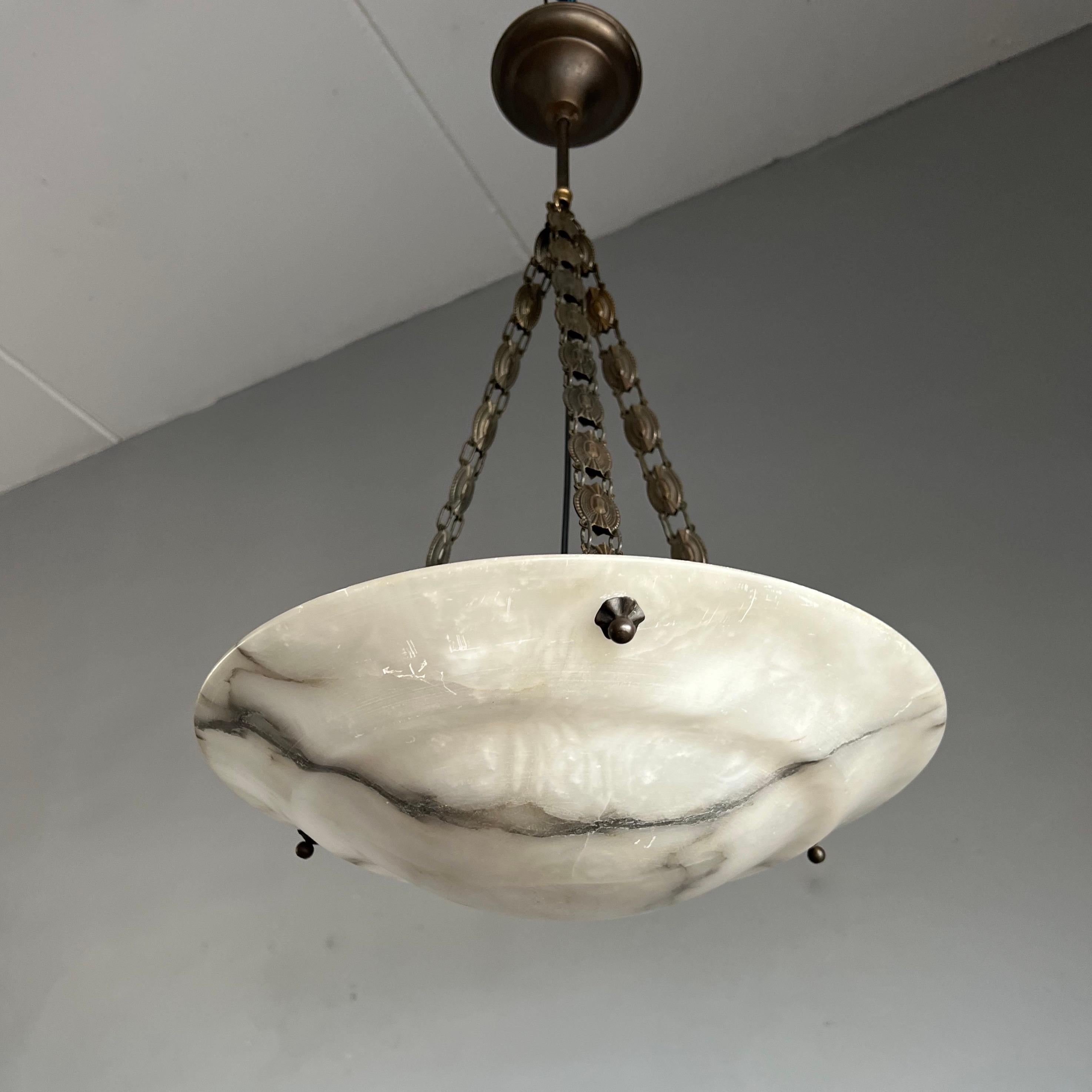 Good size and great design alabaster pendant from the European Art Deco era.

This rare shape and ideal size Art Deco light fixture comes with a stunning and good condition, polished alabaster shade. Both on and off this striking shade with its