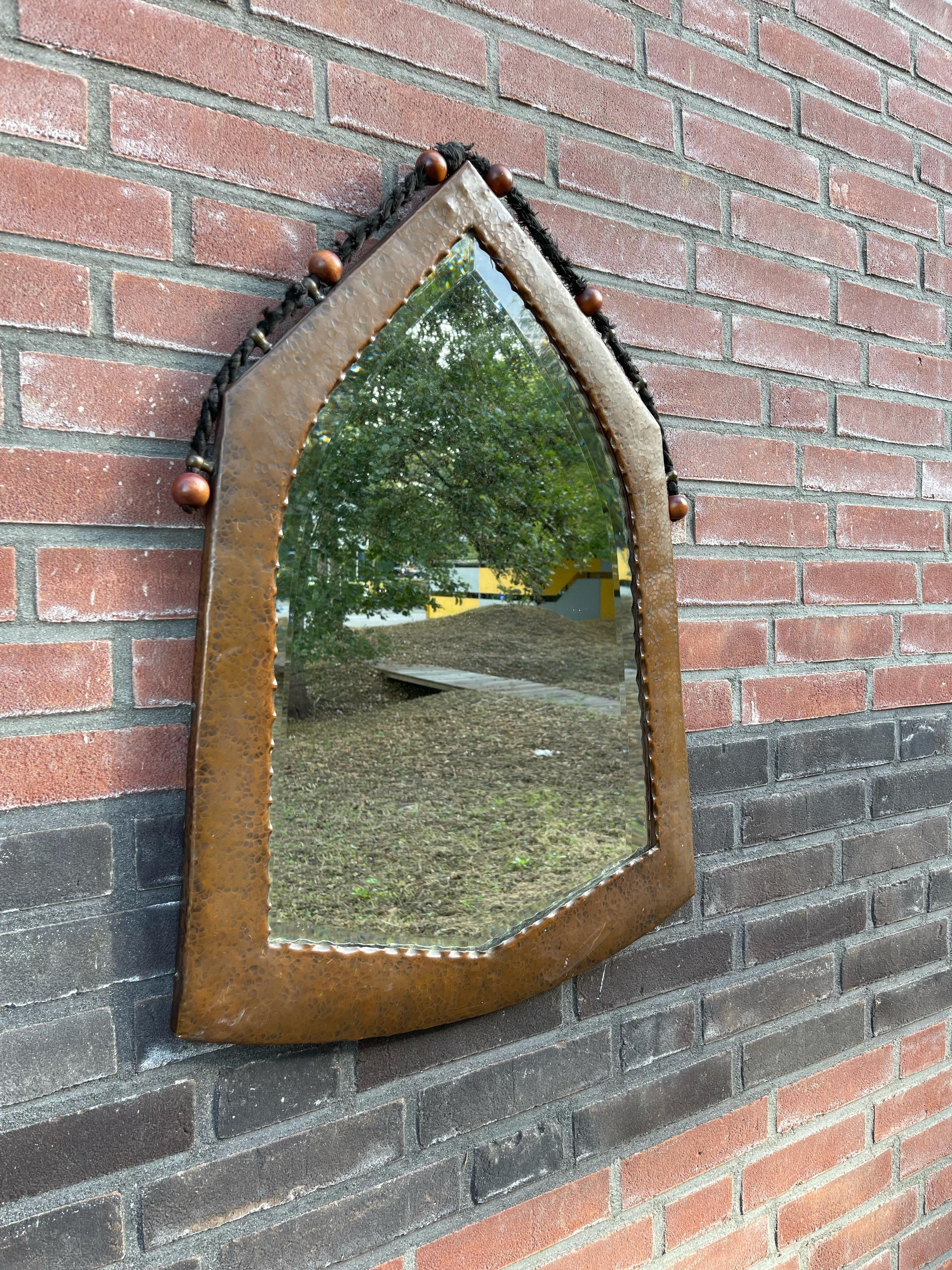 Early 1900s, great design and all handcrafted Arts and Crafts wall mirror with original beveled glass and black rope.

This truly stylish and practical size Arts & Crafts antique with its original, thick glass beveled mirror is an absolute joy to