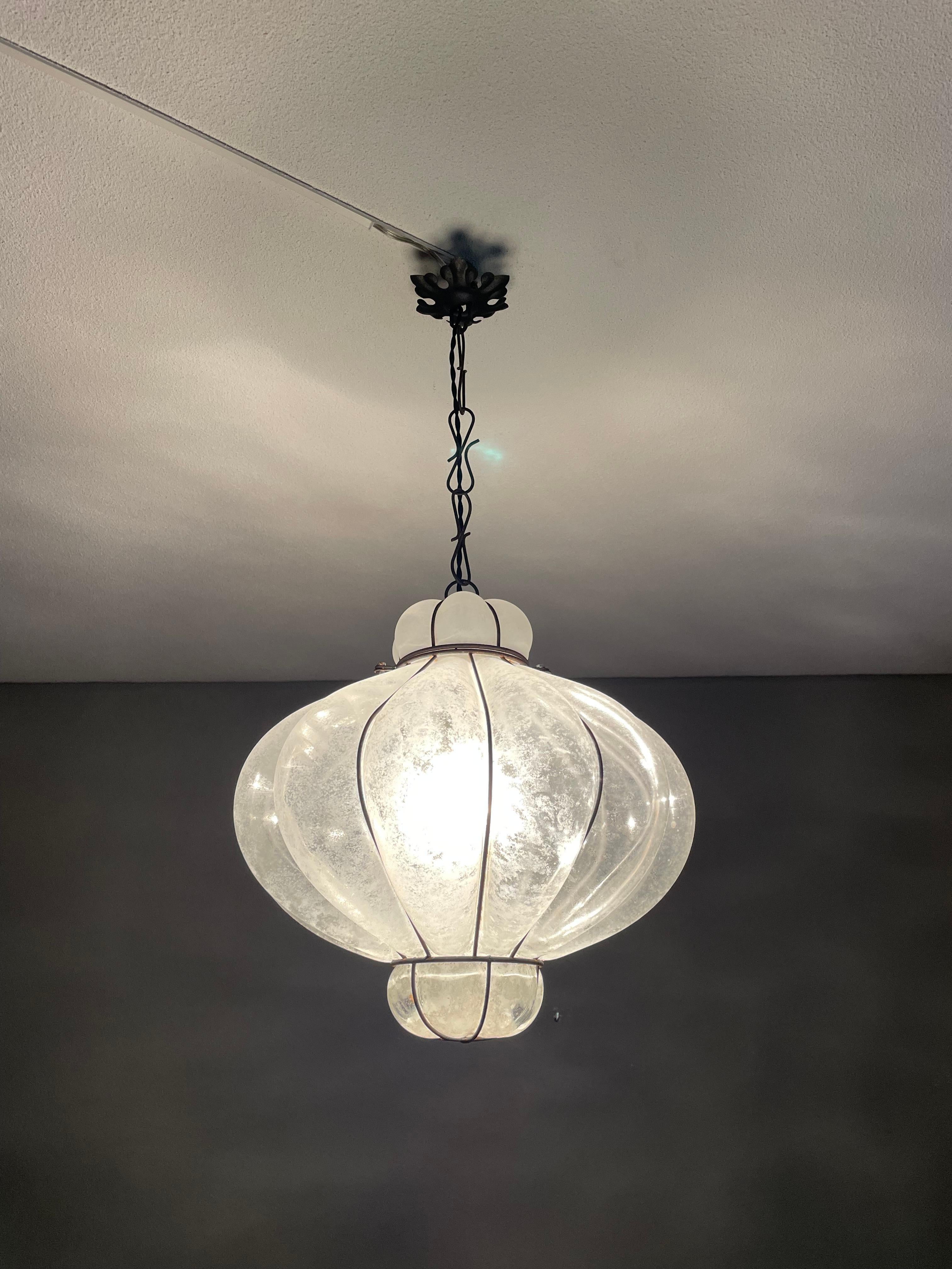 Beautiful midcentury made Italian light fixture.

This finer quality workmanship pendant from mid-20th century Italy is a real eyecatcher and both with the light switched on and off it is a real beauty to look at. Especially with the light switched