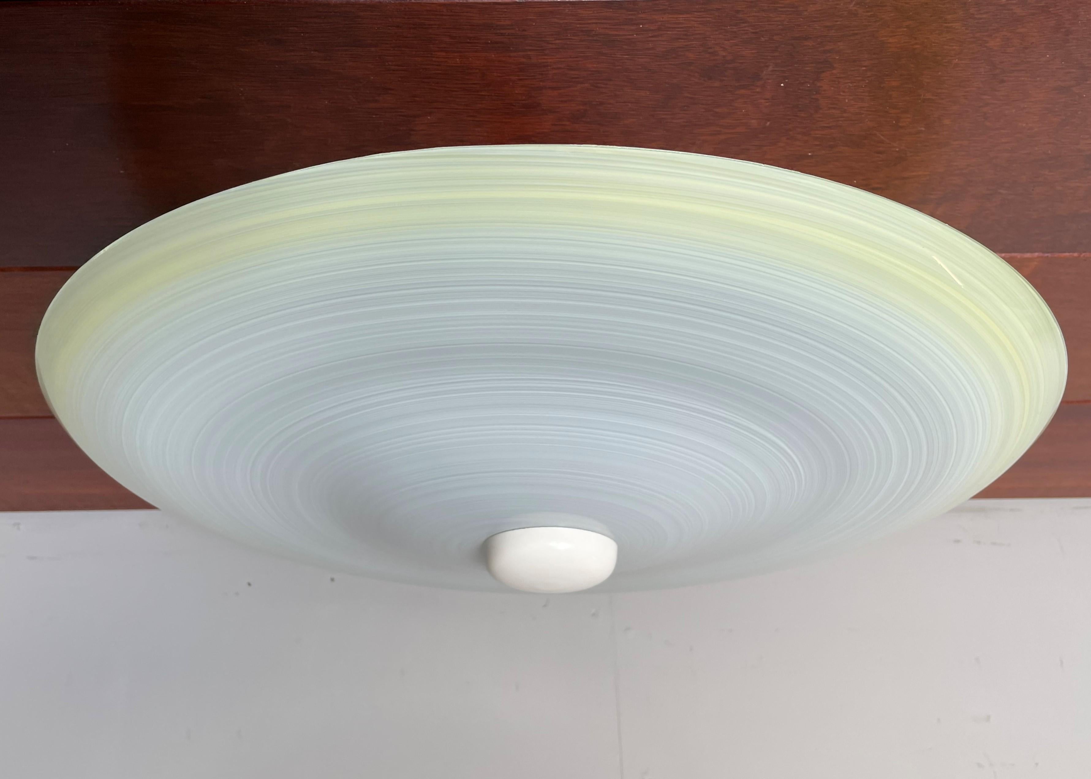 Very stylish Mid-Century Modern, 'swirling' circular pattern ceiling lamp.

This vintage light fixture has a beautiful look and feel and you will hardly ever find a light fixture from the Mid-Century Modern era with a more timeless glass shade.