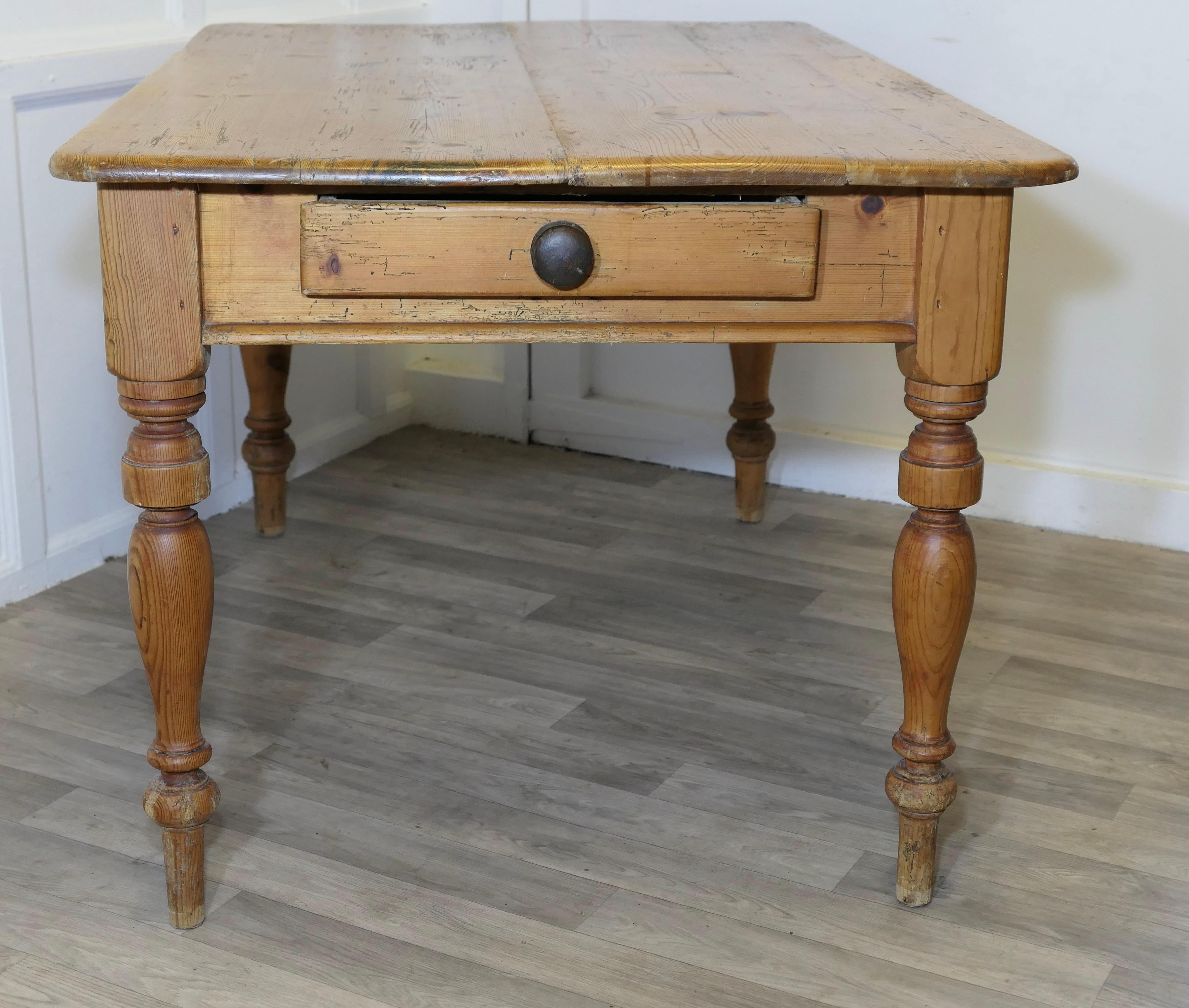 Bonne table de cuisine de ferme en pin robuste

Une bonne table de ferme, le plateau à 4 planches est en pin massif, elle a un grand tiroir et de jolis pieds tournés.
La table est très solide et robuste, avec quelques signes de caractère et