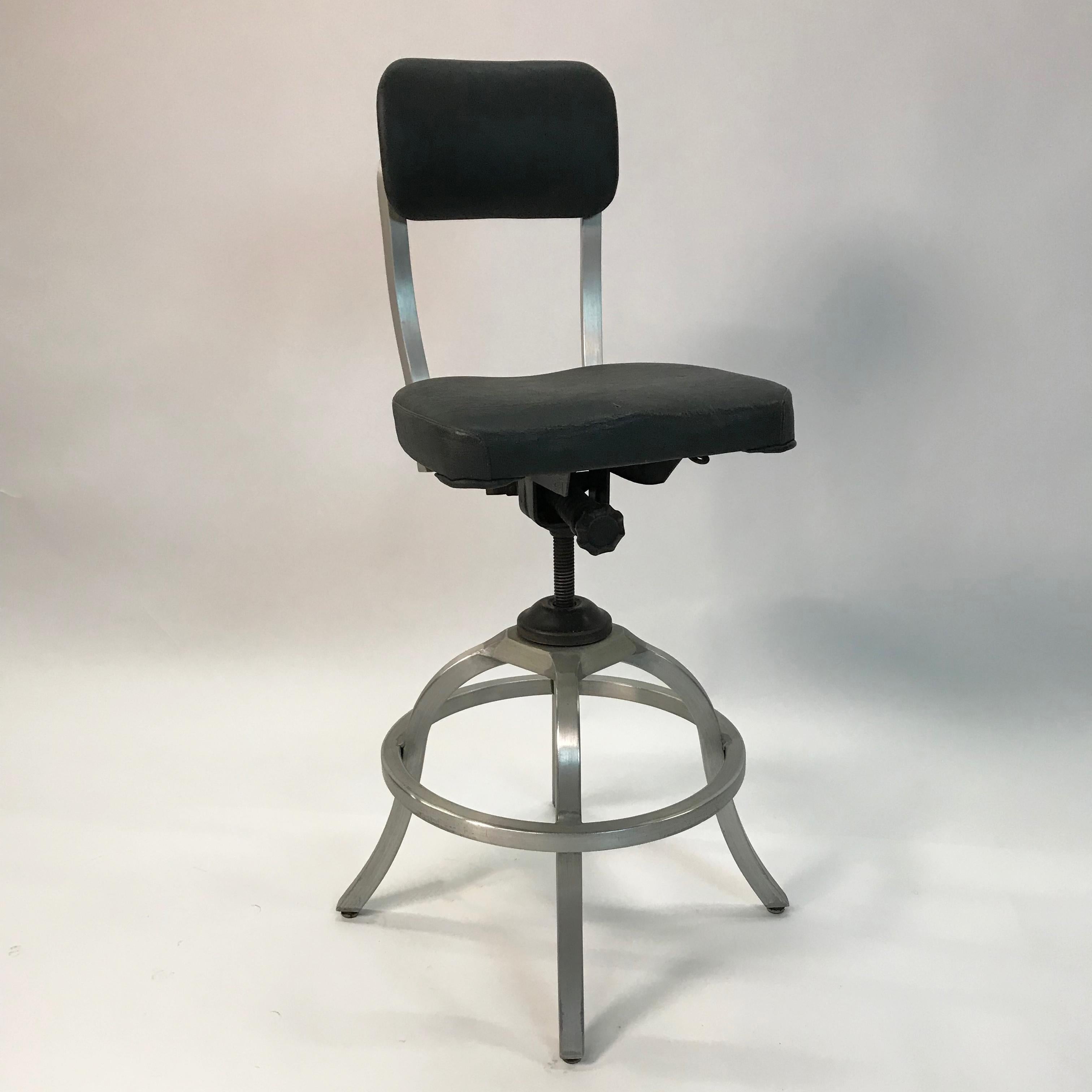Midcentury, industrial, drafting stool by Goodform General Fireproofing Company features an aluminum frame with vinyl seat and back. Measures: Seat height is adjustable from 25-30 inches and back goes from 40 - 44 inches.