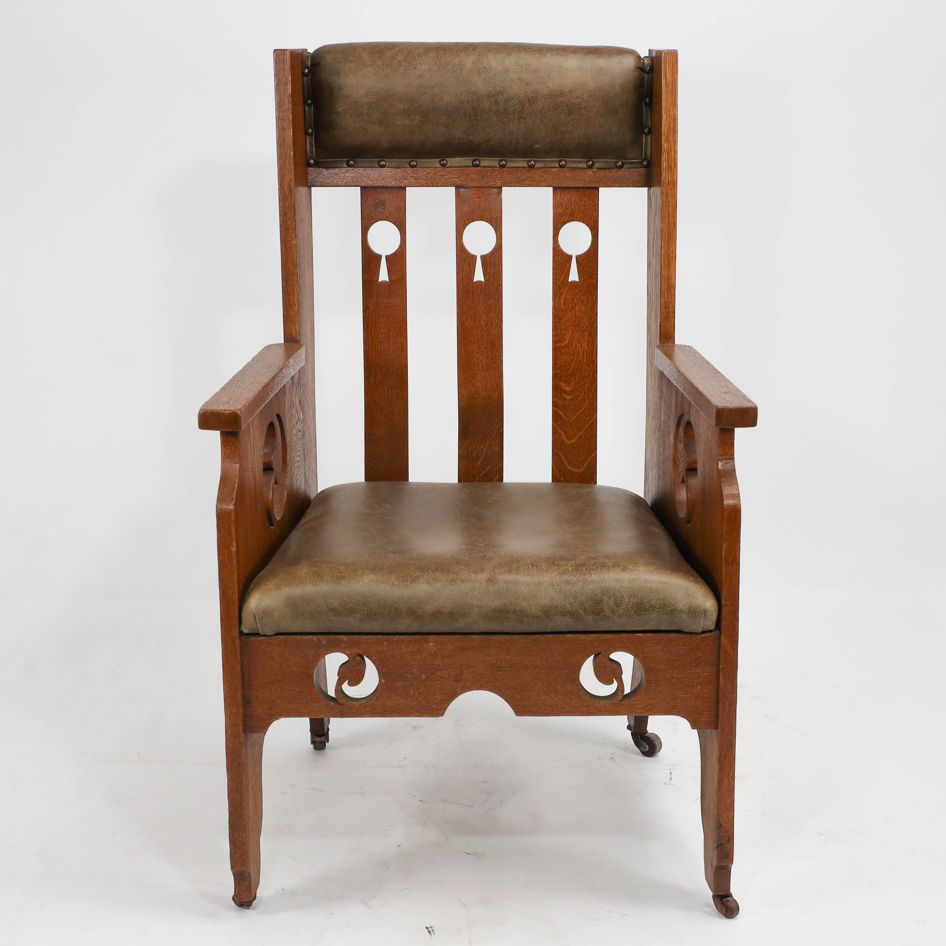 Goodyers of Regent St. A good Arts & Crafts oak armchair, with stylized lolly-pop cut-outs to the back splats and stylized floral cut-outs to the side arms and to the front apron with shaped details to the lower sides, professionally recovered in a