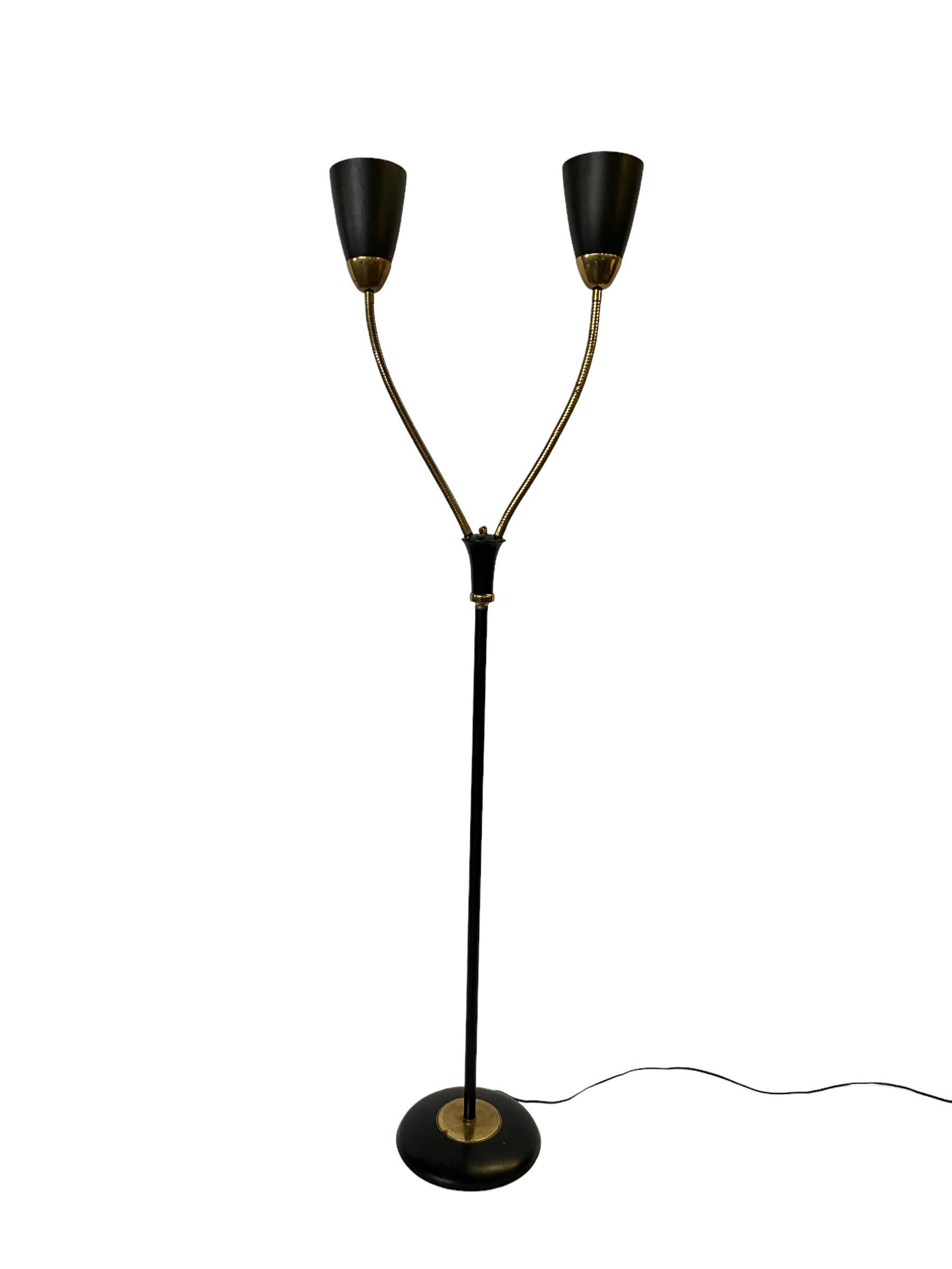 Double Gooseneck floor lamp in the style of Gerald Thurston. The lamp features black-enameled brass, gooseneck stems, and is in good vintage condition. Three-way switch on stem allows for one, the other, or both heads to illuminate. Gooseneck arms