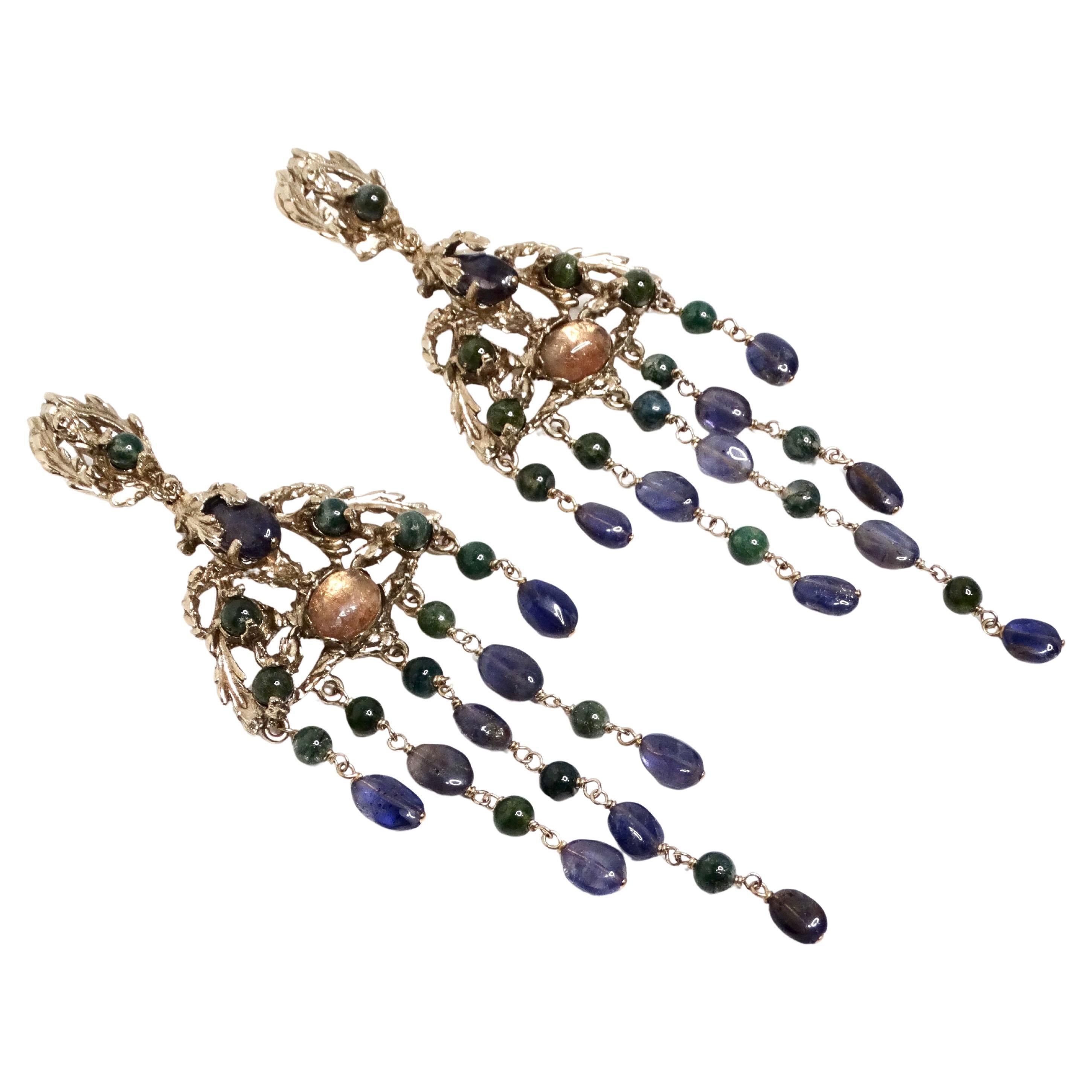 The Goosens Paris Ornate Multicolor Gemstone Dangle Earrings are a stunning example of exquisite craftsmanship and timeless elegance. Crafted in silver-tone metal, these earrings feature an ornate design reminiscent of delicate leaves, intricately