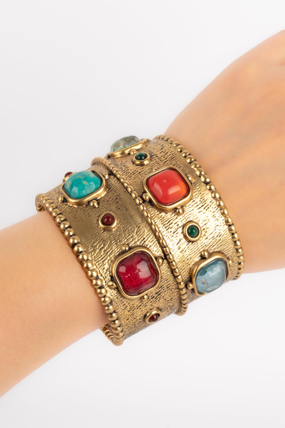 Goossens - (Fabriqué en France) Bracelet manchette en métal doré orné de cabochons en pâte de verre et de cabochons en pierre dure. Taille M.

Informations complémentaires :
Condit : Très bon état.
Dimensions : Circonférence : 14 cm - Ouverture : 3