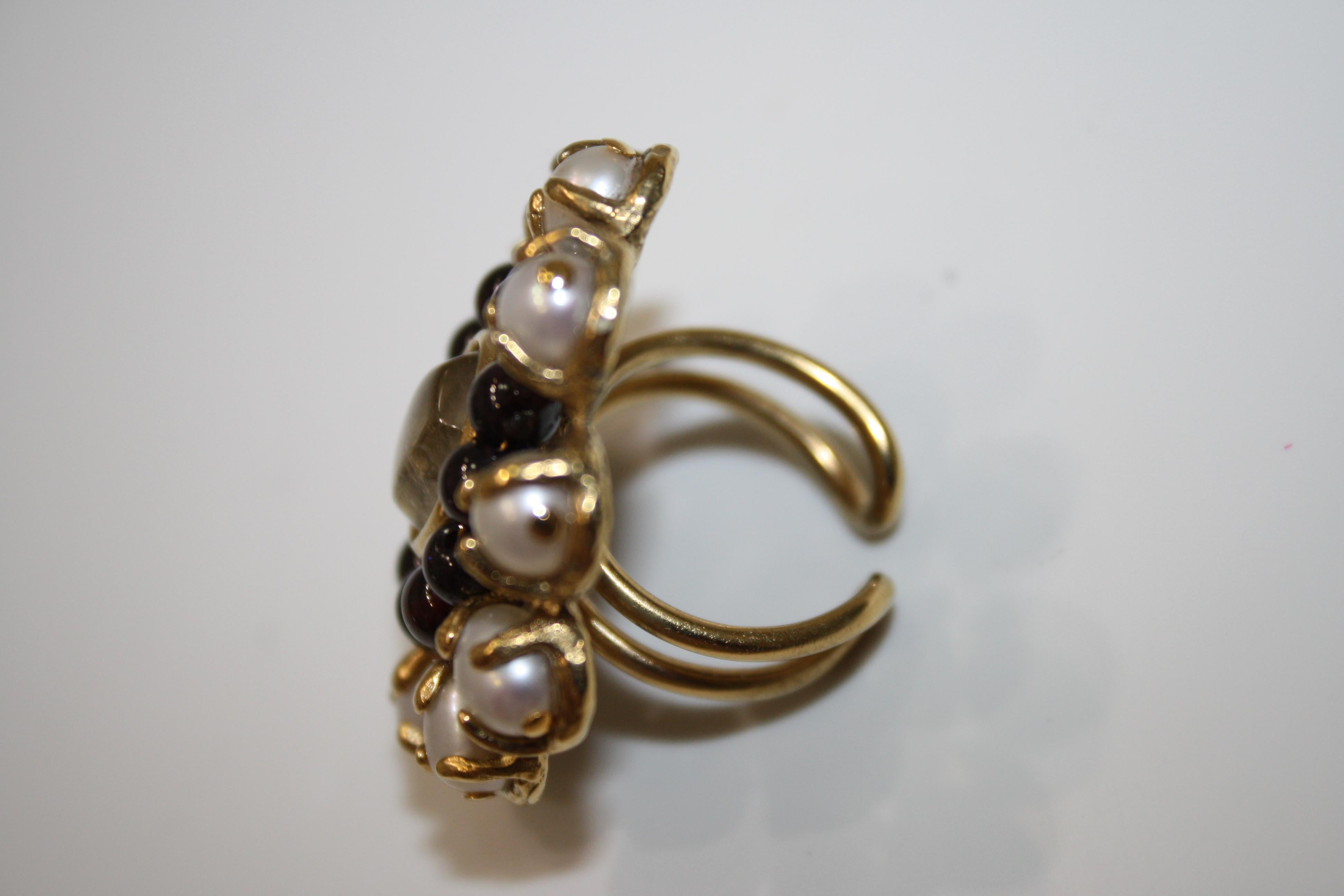 Adjustable ring in classic Goossens style.
24kt gold plated brass Perle Baroque floral ring from featuring pearl embellishments , garnet stones and faceted rock crystal cabochon
Each piece of jewellery made by the House of Goossens is anchored in a