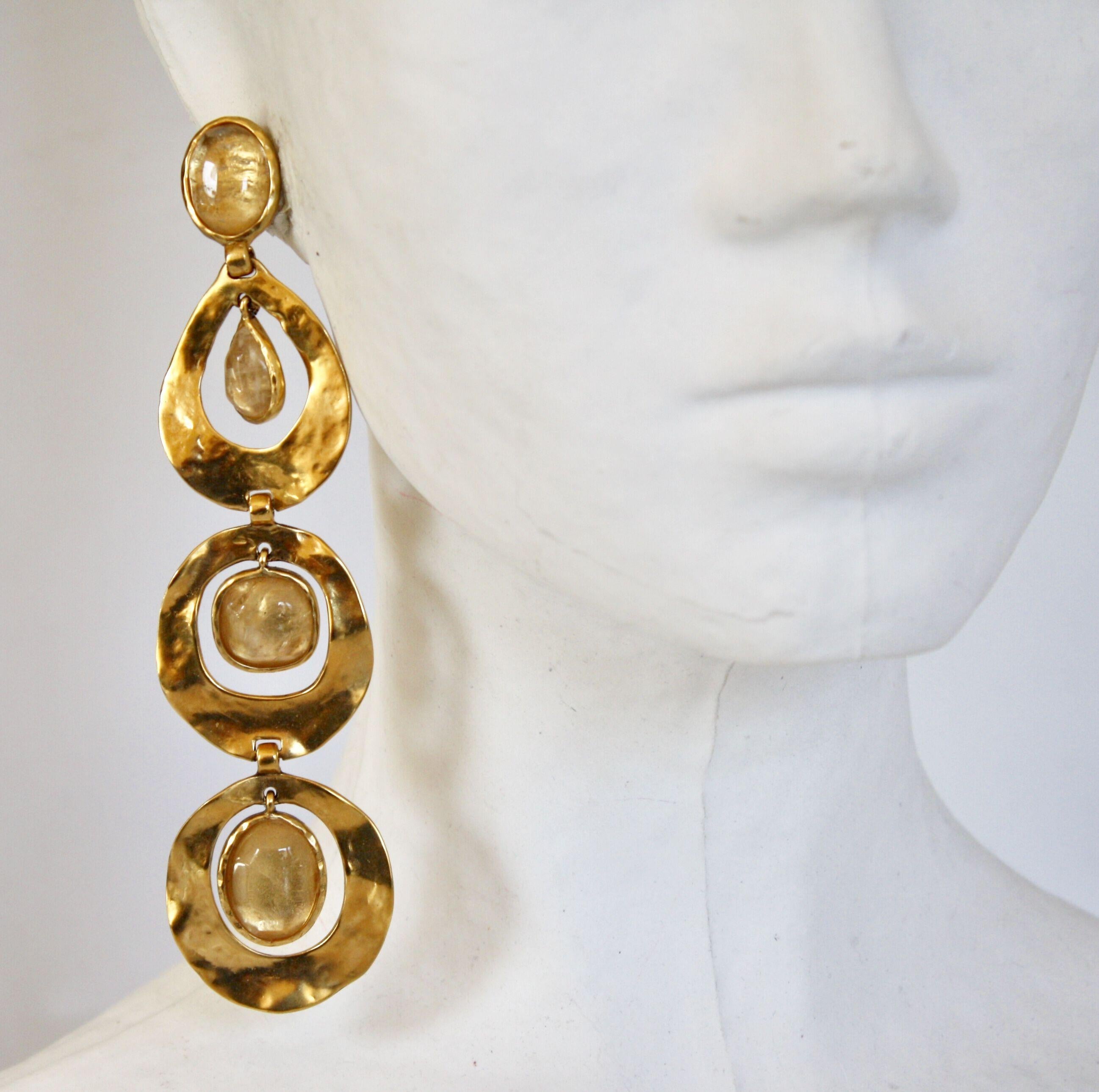 Long statement clip earrings in hammered gold with rock crystals from Goossens Paris. 