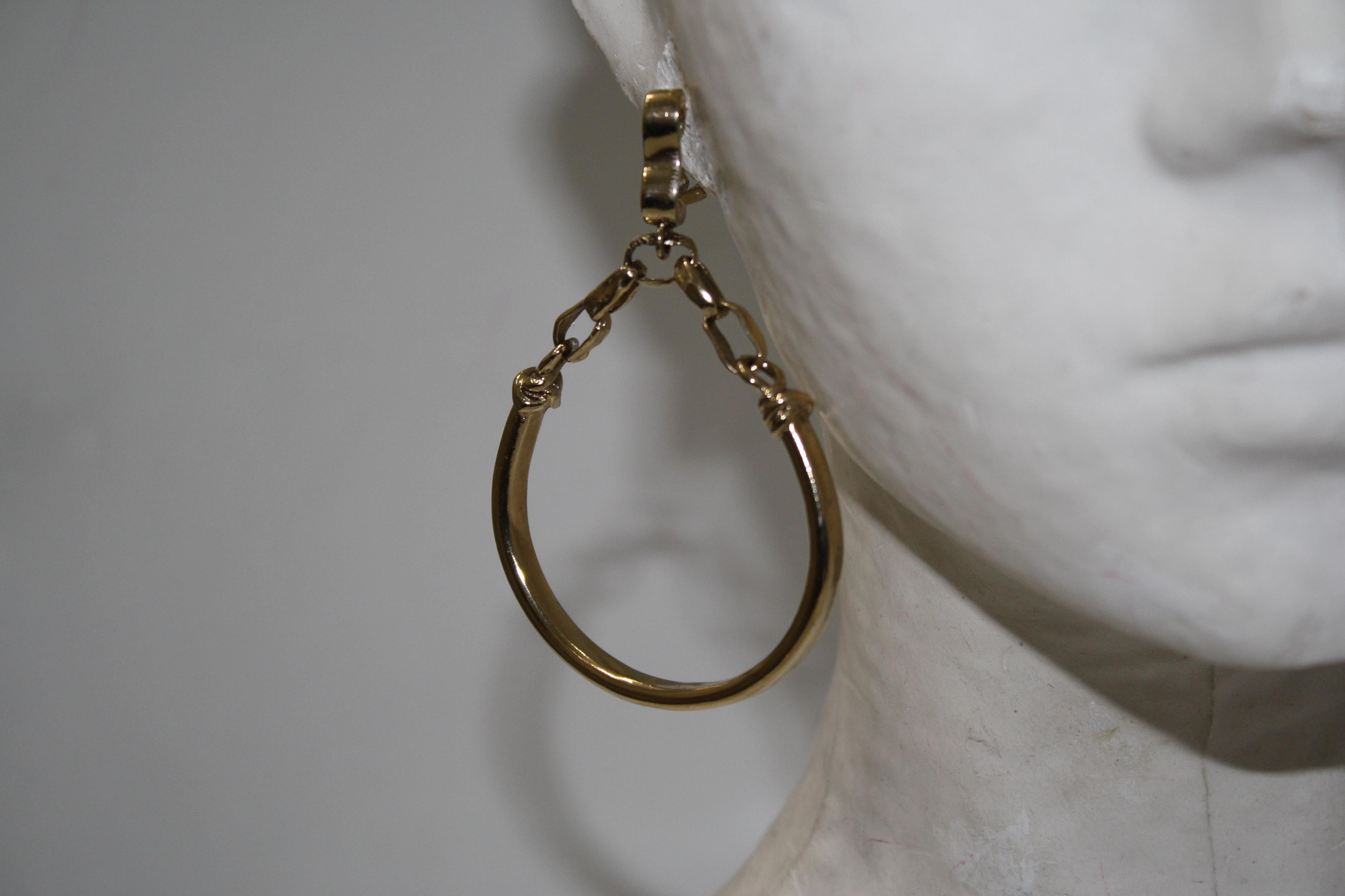 French back( studs and flap back) .Chain is holding circle hoop. Made of brass dipped in pale gold.
