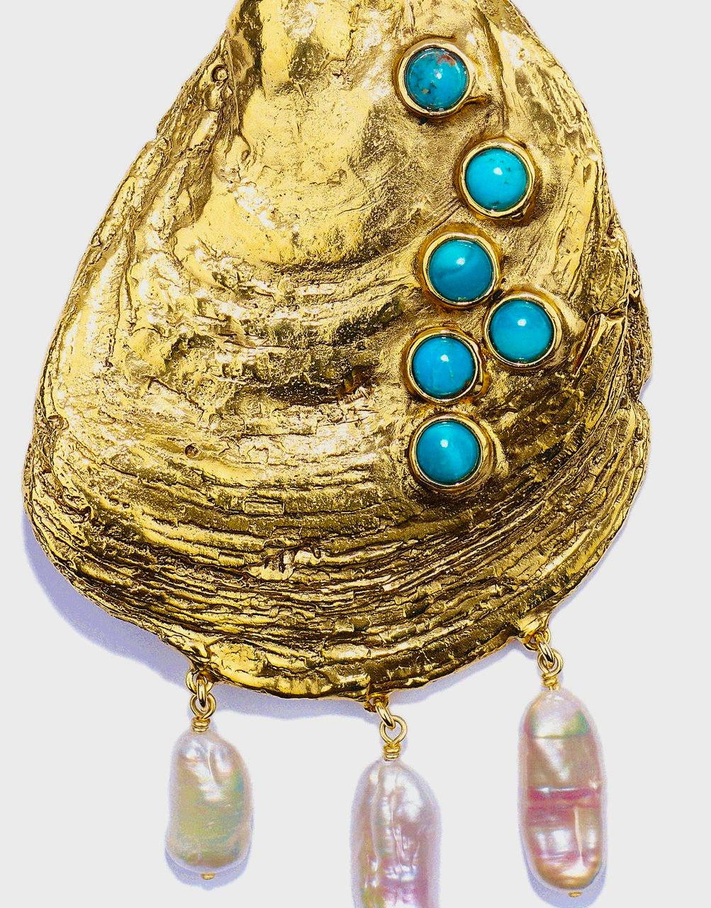 Collar de concha grande de la colección Circé. Con la llegada de los días cálidos, la colección Circé desvela conchas marinas realzadas por turquesas, lapislázuli, piedras de ágata verde y perlas barrocas. Evocando la majestuosa forma de una concha