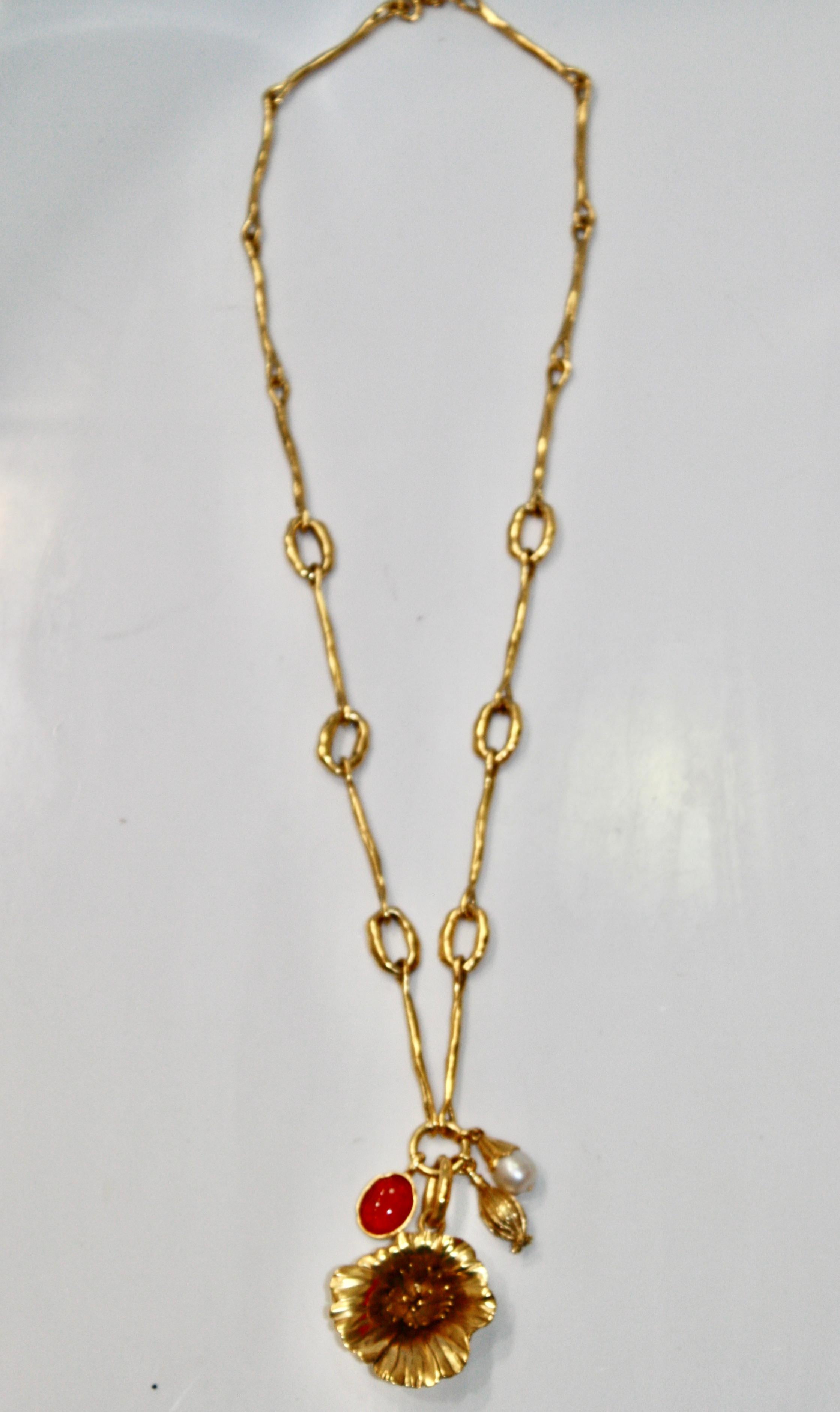 Ce collier fleur de pavot est composé d'un bouton de fleur sur le point d'éclore, d'une eau douce baroque, d'un cabochon en cristal de roche teinté grenadine.
Le collier est en bronze trempé dans un bain d'or 24 carats de couleur or jaune.