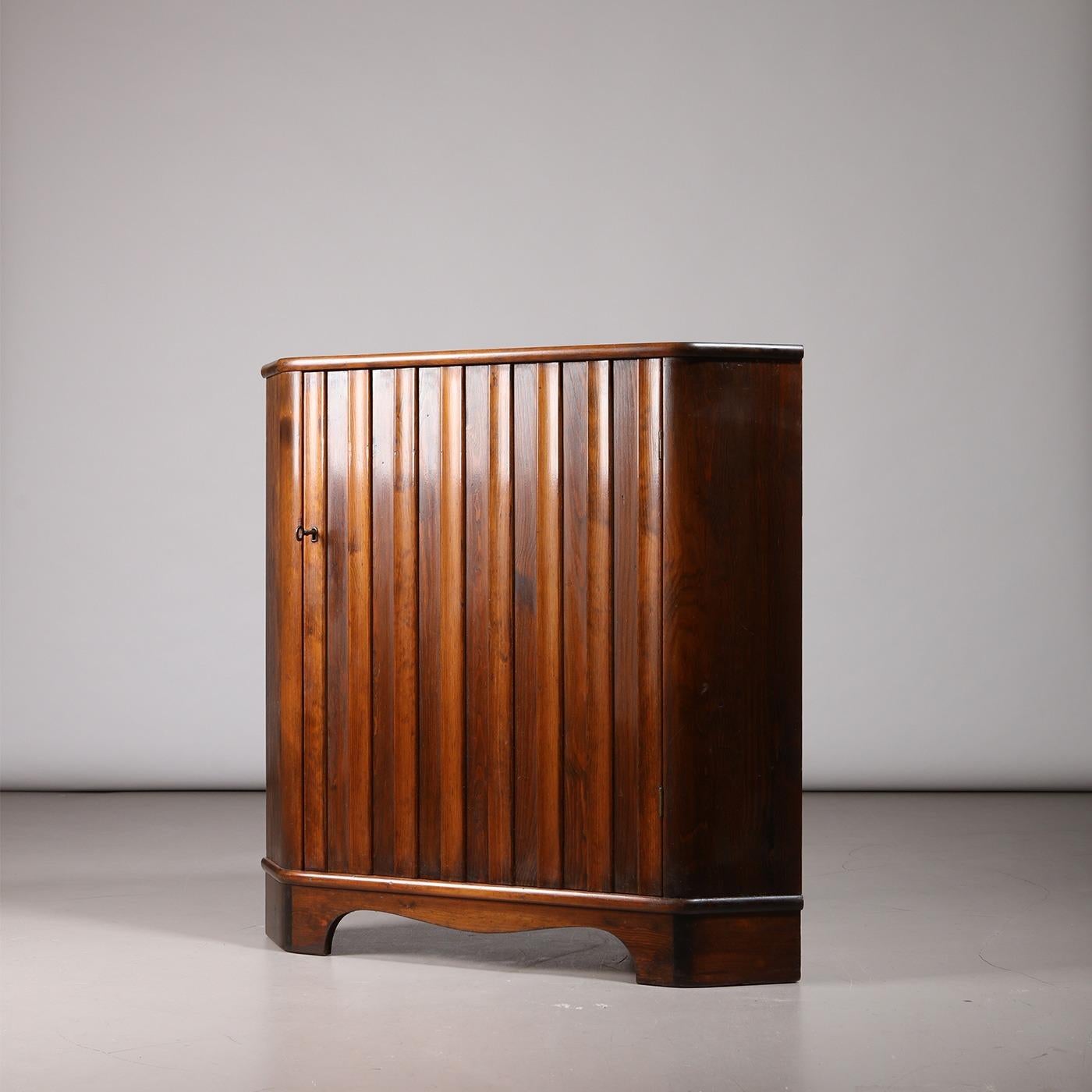 'Sportstugemöbler' corner cabinet, designed by Göran Malmvall. Produced by Karl Andersson & Söner in Sweden, 1950s. Made from dark stained pine. Interior with two shelves, single door with vertical reliefs. The cabinet has been expertly