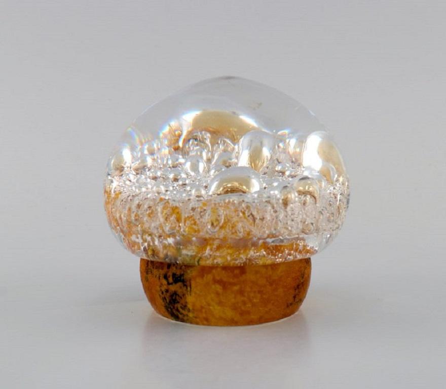 Göran Wärff for Kosta Boda. Paperweight shaped as a mushroom in amber-coloured and clear mouth-blown art glass with inlaid bubbles. 
Swedish design, 1970s.
Measures: 10.5 x 9.5 cm.
In excellent condition.
Engraved signature.