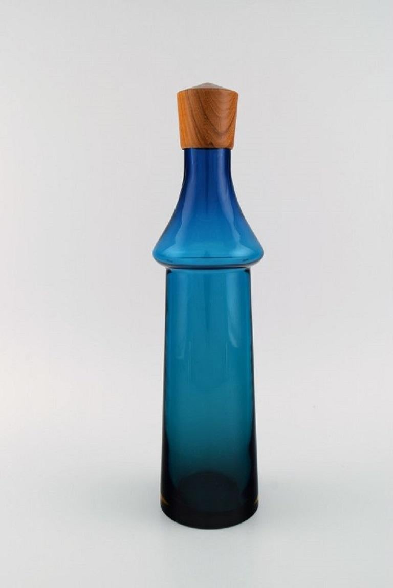 Göran Wärff for Pukeberg. 
Large Tropico decanter in blue mouth-blown art glass with teak stopper. 
Swedish design, 1960s.
Measures: 37 x 10 cm.
In excellent condition.
 