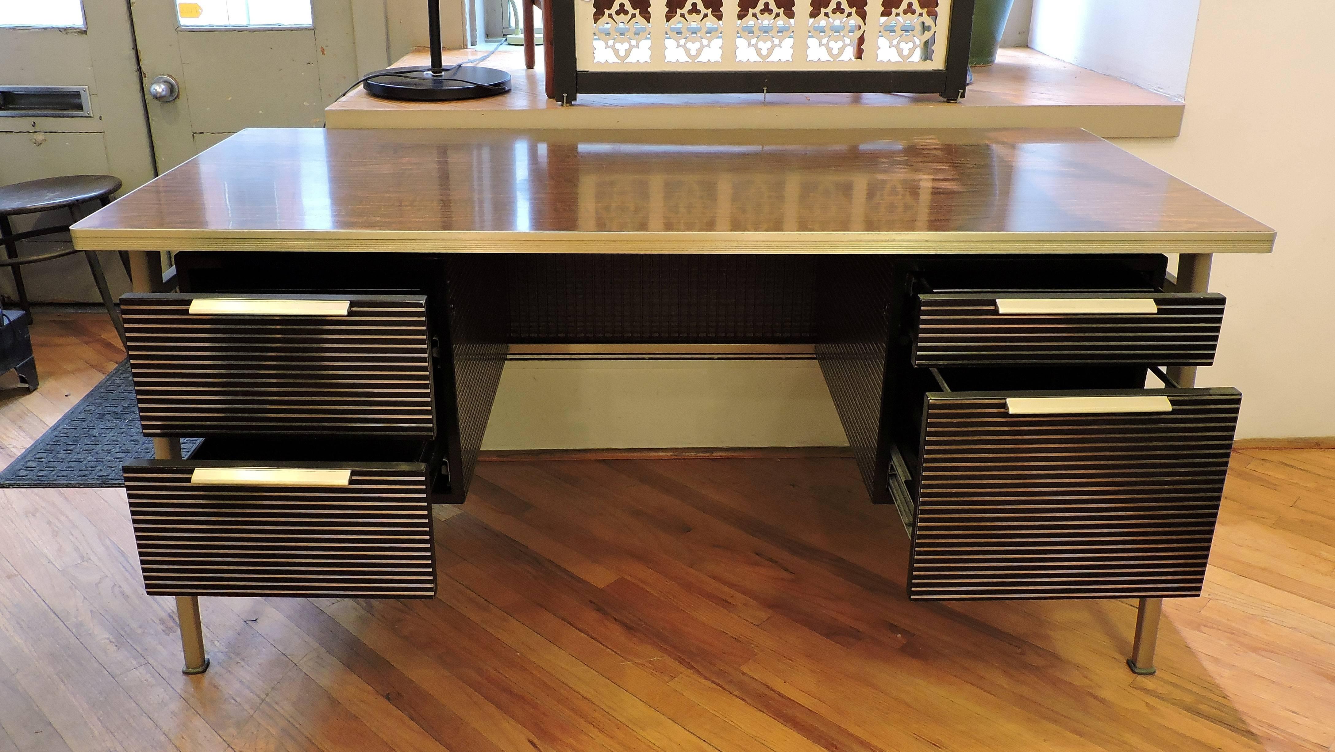 Very cool Mid-Century Modern desk designed by modern design architect Gordon Bunshaft (1909-1990) and manufactured by the General Fireproofing Company. This desk is made of aluminium with a woodgrain laminate top and has four drawers which includes