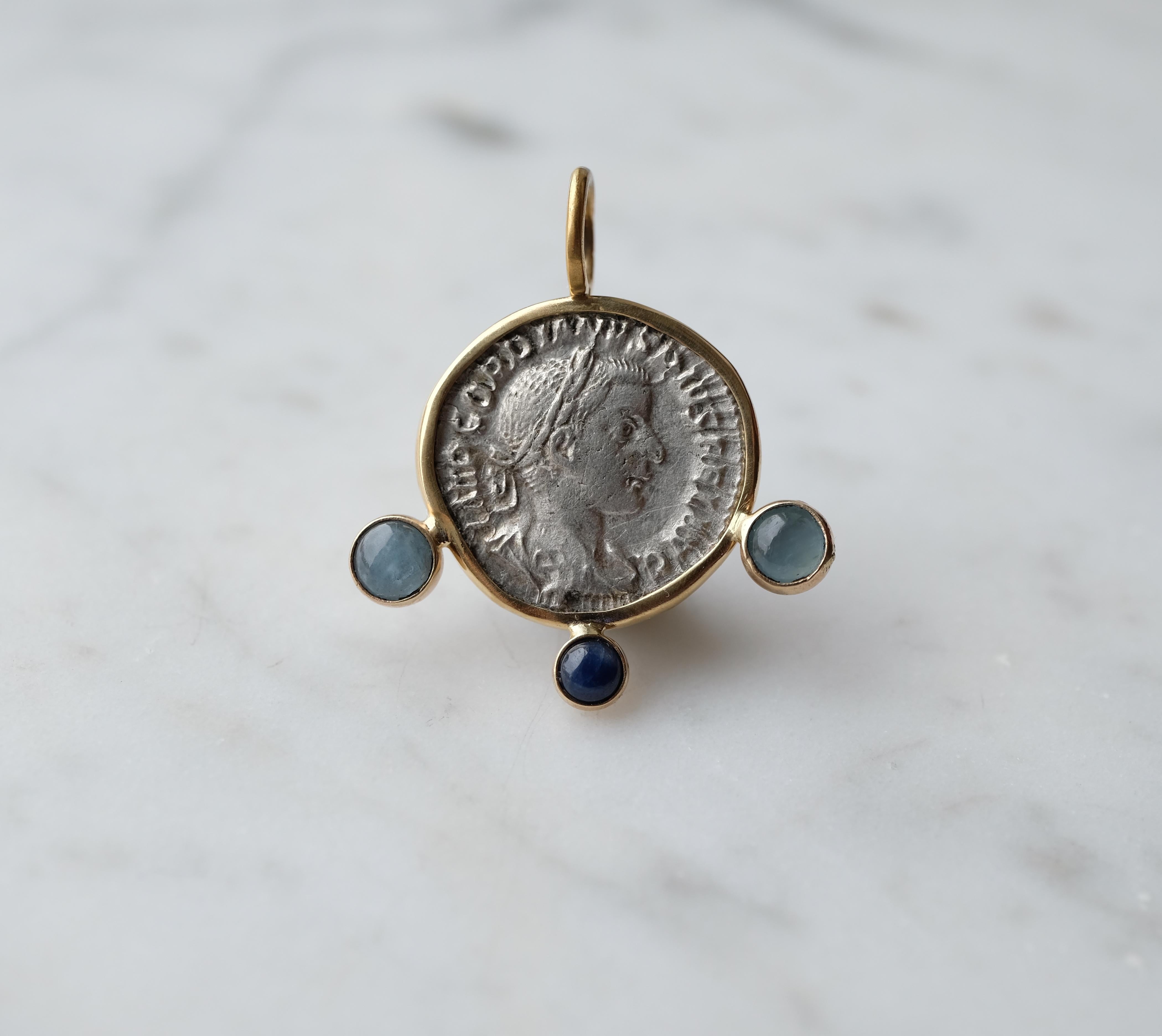 Il s'agit d'un pendentif unique en son genre représentant une pièce de l'empereur Gordien III. J'ai soigneusement ajouté deux aigues-marines et un saphir à la monture en 18k. La pièce a été acquise auprès d'un grand marchand de pièces anciennes.