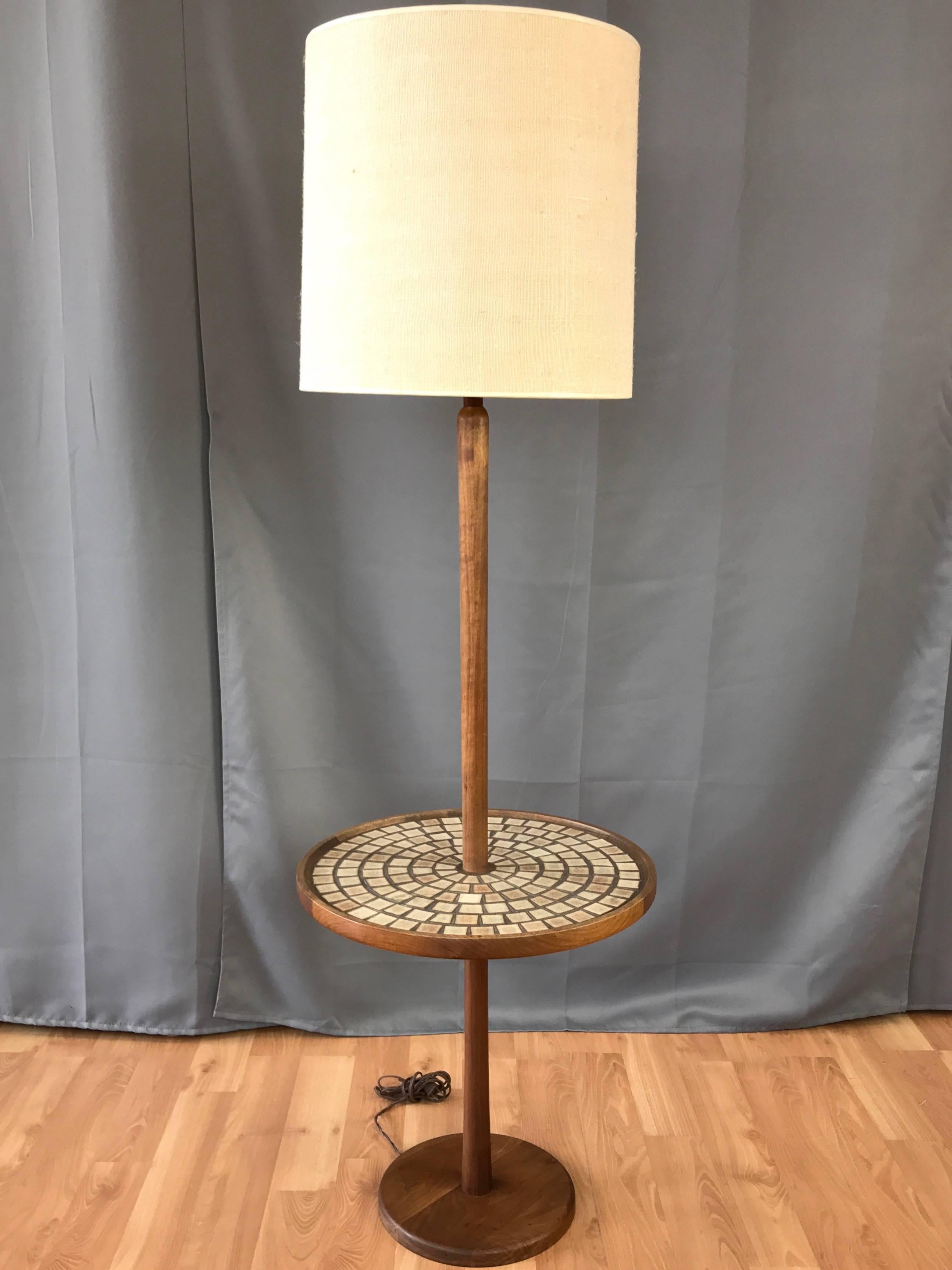 A model W4 walnut floor lamp with integrated tile top table designed by Gordon & Jane Martz for Marshall Studios, and introduced in the early 1960s.

Handsomely crafted stem and base are solid walnut, with very nice design details on display