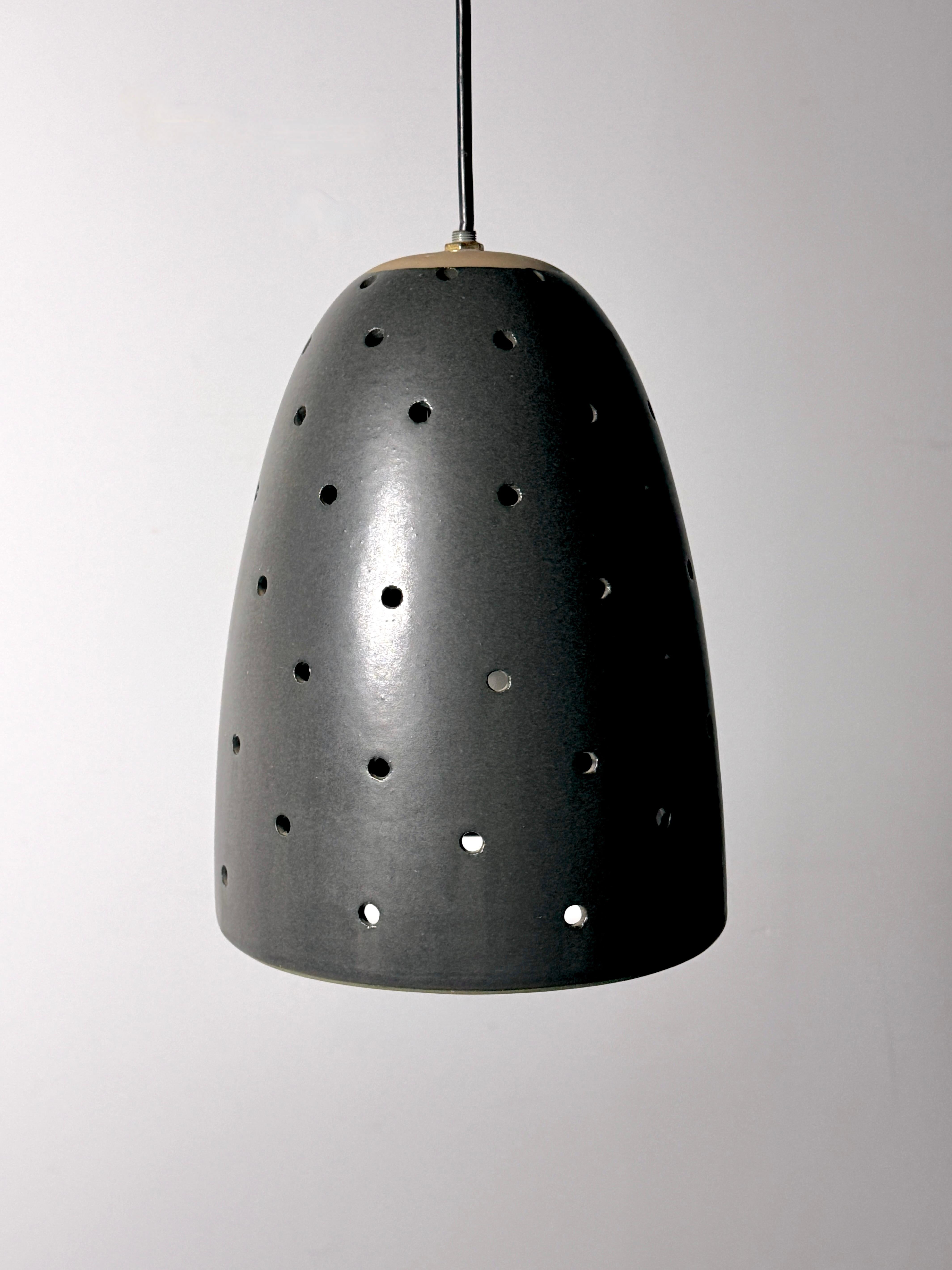 Rare hanging pendant lamp designed by Gordon and Jane Martz for Marshall Studios 1960s

Modern 236 in matte black glaze with perforated holes for a soft and enchanting light pattern

8.25 inch diameter
11 inch height 