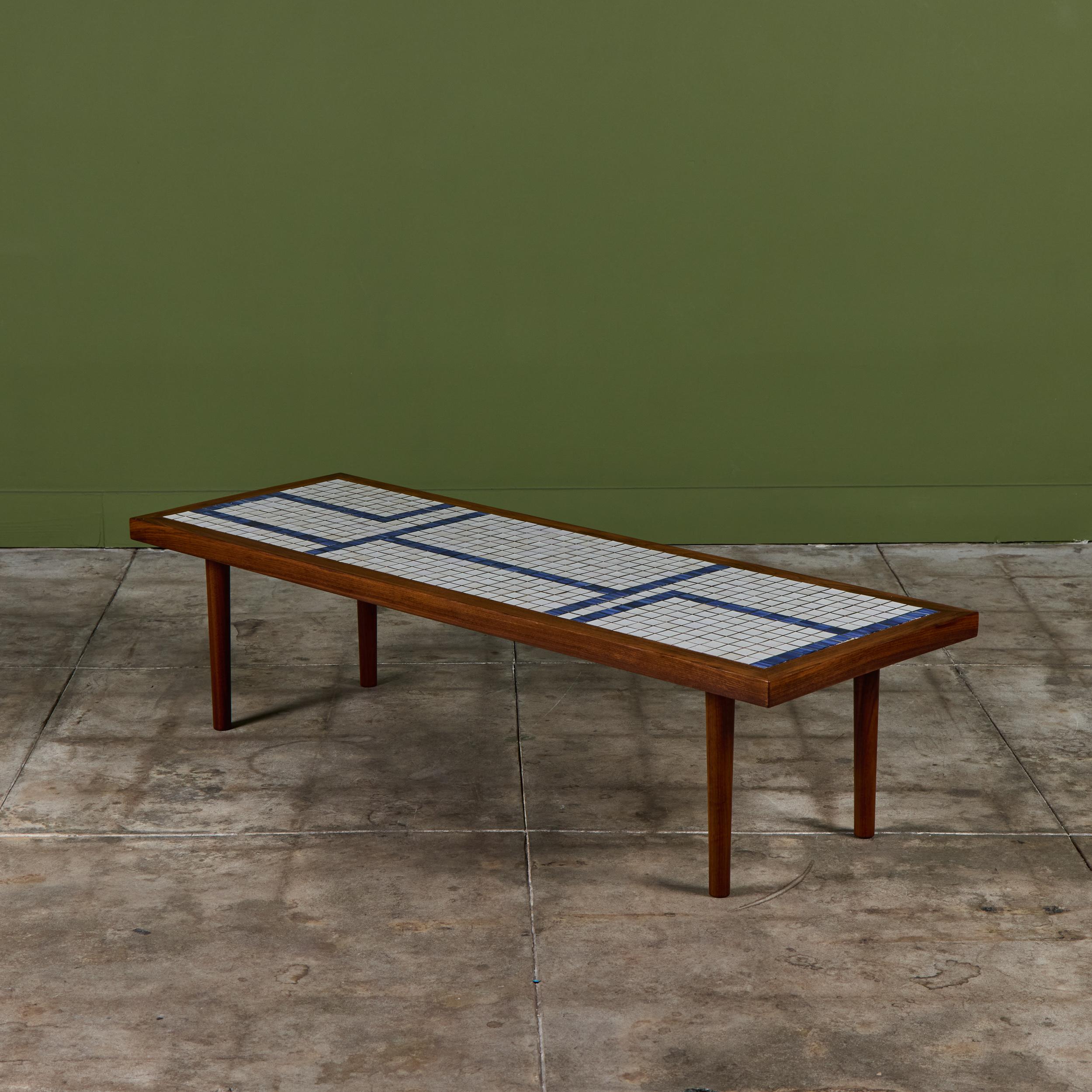 Rectangular coffee table by Gordon & Jane Martz for Marshall Studios. The walnut table top is inlaid with white square ceramic tiles with blue square tiles throughout creating a linear design. The legs and frame of the table are solid