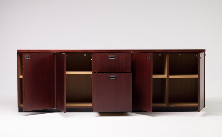 Red dye teak credenza with chrome recessed pulls designed by Gordon Bunschaft and manufactured by De Coene for the Belgium Lambert Bank, circa 1960. The credenza features two drawers and four features two storage compartments with a single interior