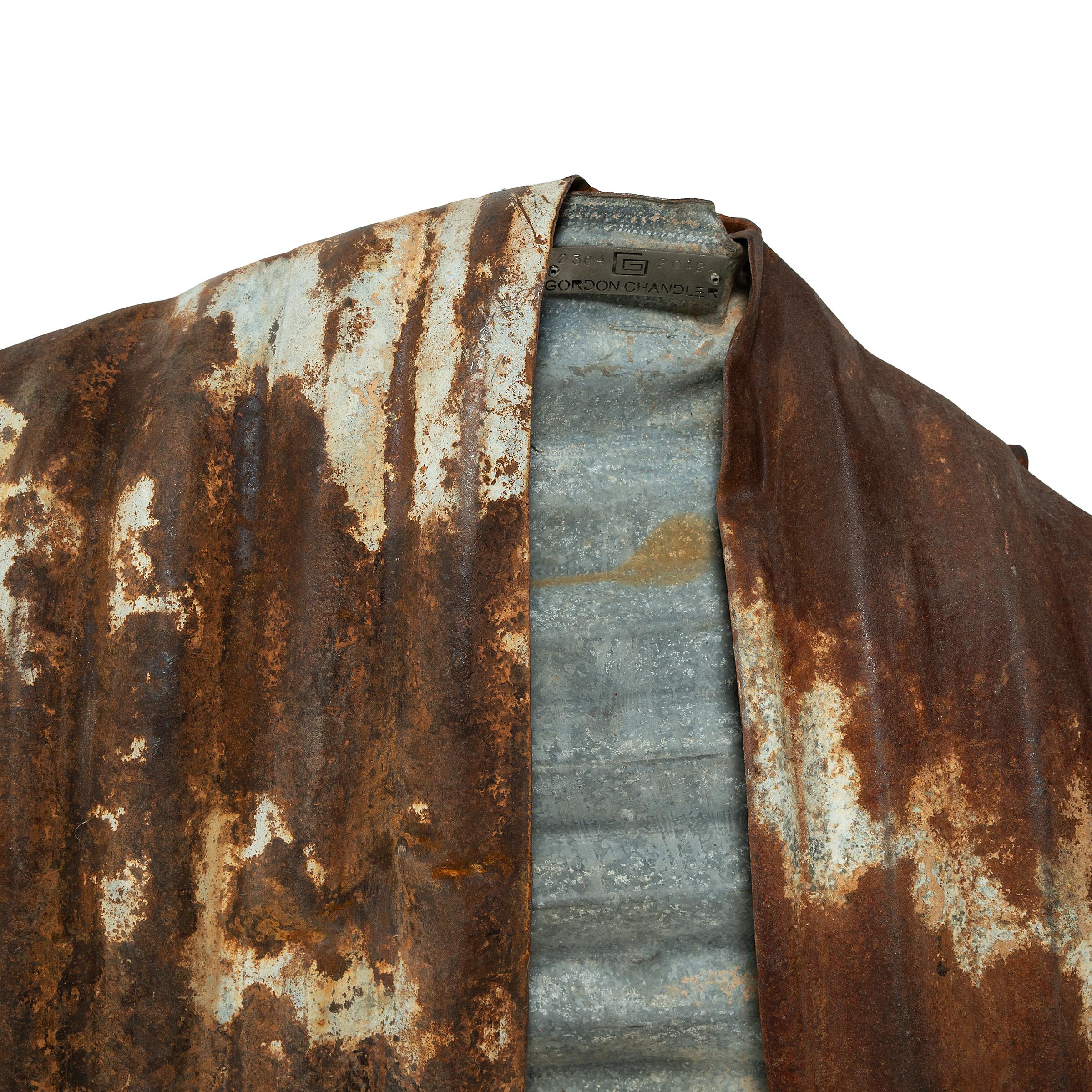 Après avoir découvert un tambour en acier usé par le temps qui avait été déformé pour ressembler à la manche d'un vêtement, l'artiste Gordon Chandler a eu l'idée de se lancer dans une série de kimonos sculptés à partir de déchets métalliques