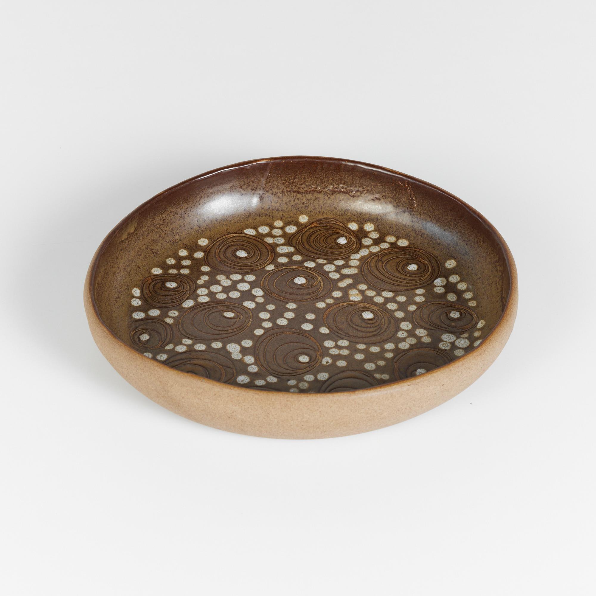 Ceramic bowl by husband-and-wife design team Gordon and Jane Martz. Produced by their family company, Marshall Studios in Indiana beginning in 1957. The stoneware ceramic bowl is glazed on the interior and comprised of earth tone shades. The