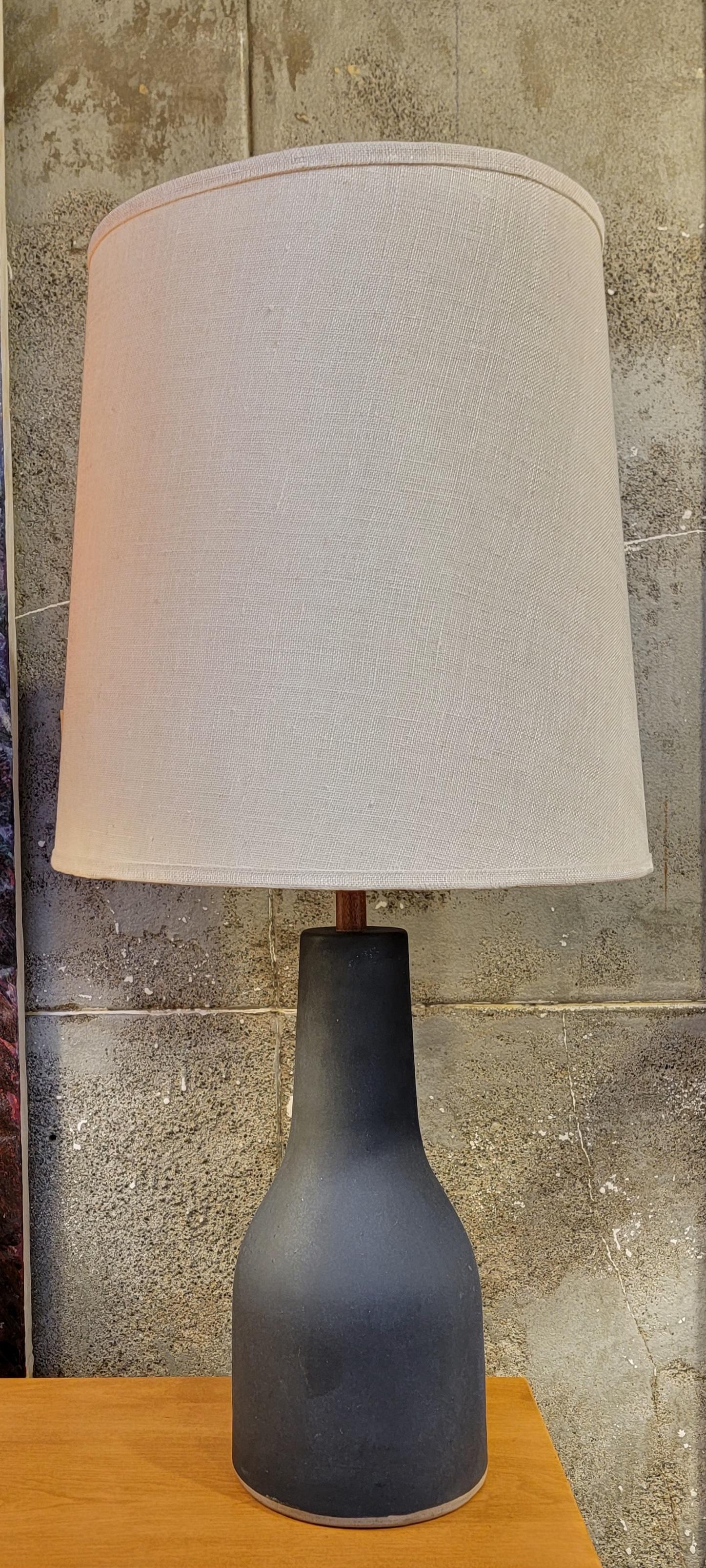 Une glaçure gris mat et des accents de teck sur cette lampe de table signée Gordon & Jane Martz. Abat-jour d'origine et embout en bois de teck d'origine. Incisé 