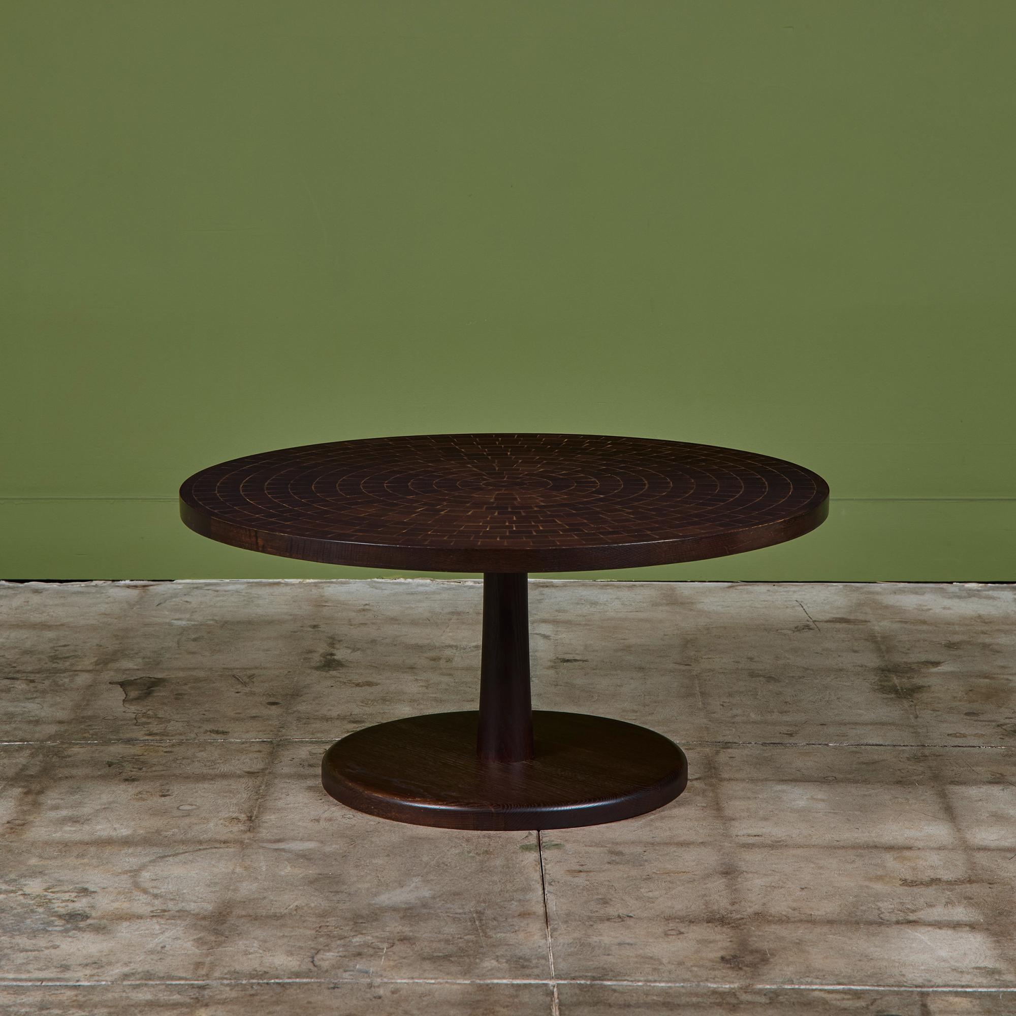 Round walnut coffee table by Gordon & Jane Martz. The table top is inlaid with square and triangular oak tiles in a geometric pattern. The frame, base and pedestal of the table are all solid walnut.

Dimensions
34
