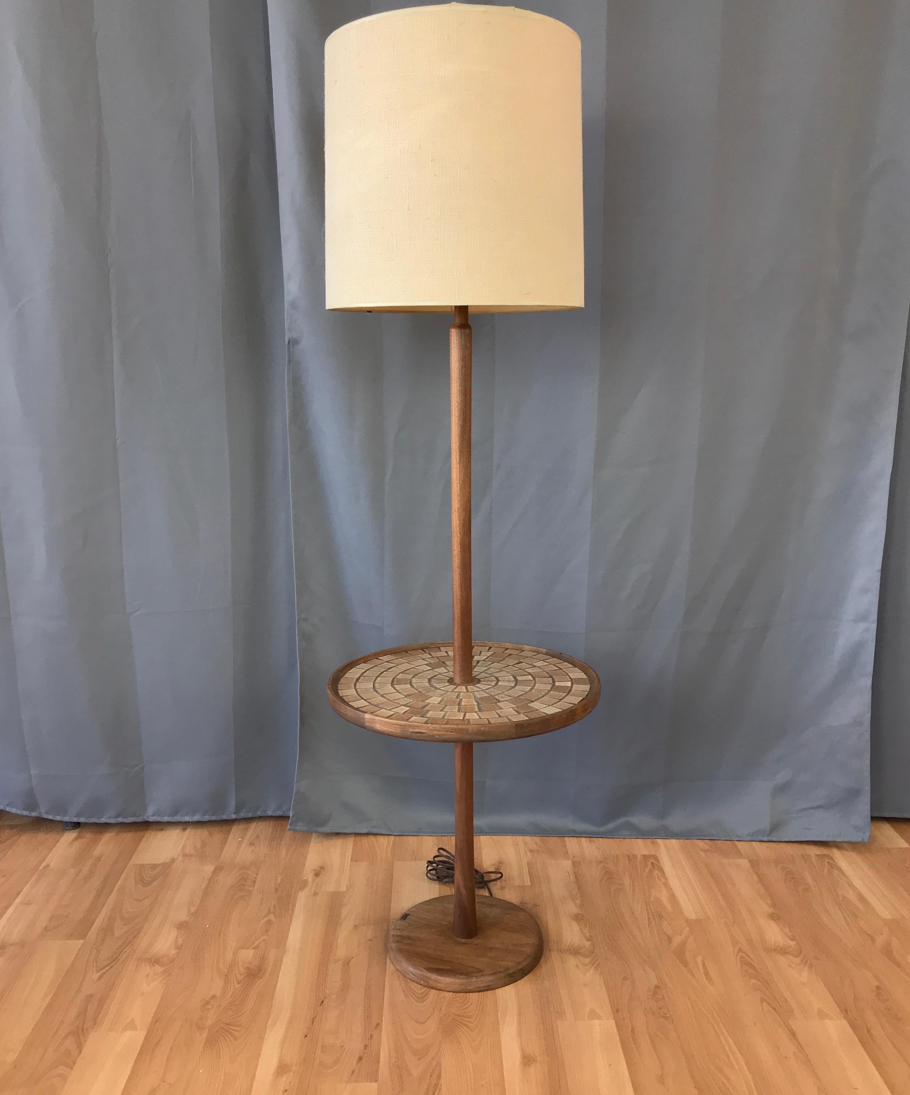A model W4 walnut floor lamp with integrated tile top table designed by Gordon & Jane Martz for Marshall Studios, and introduced in the early 1960s. 

Handsomely crafted stem and base are solid walnut, with very nice design details on display