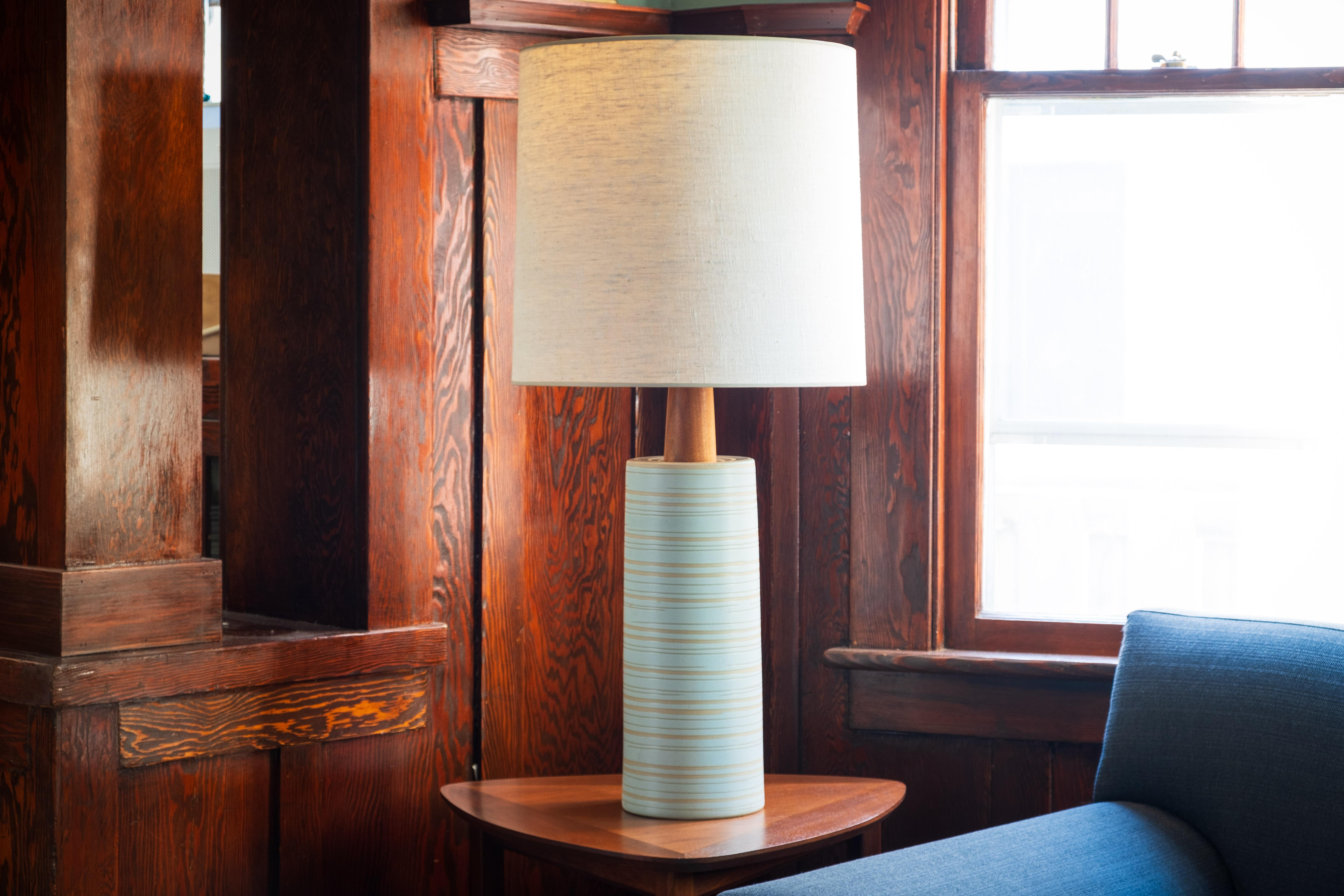 WHAT IS IT?
—
These signed Martz Model 223 lamps comes in a very light blue glaze. Just on the edge of looking white, the color is subtle but you'll notice it in the right light.

Thick and thin incised stripes circle the perimeter of the lamp from