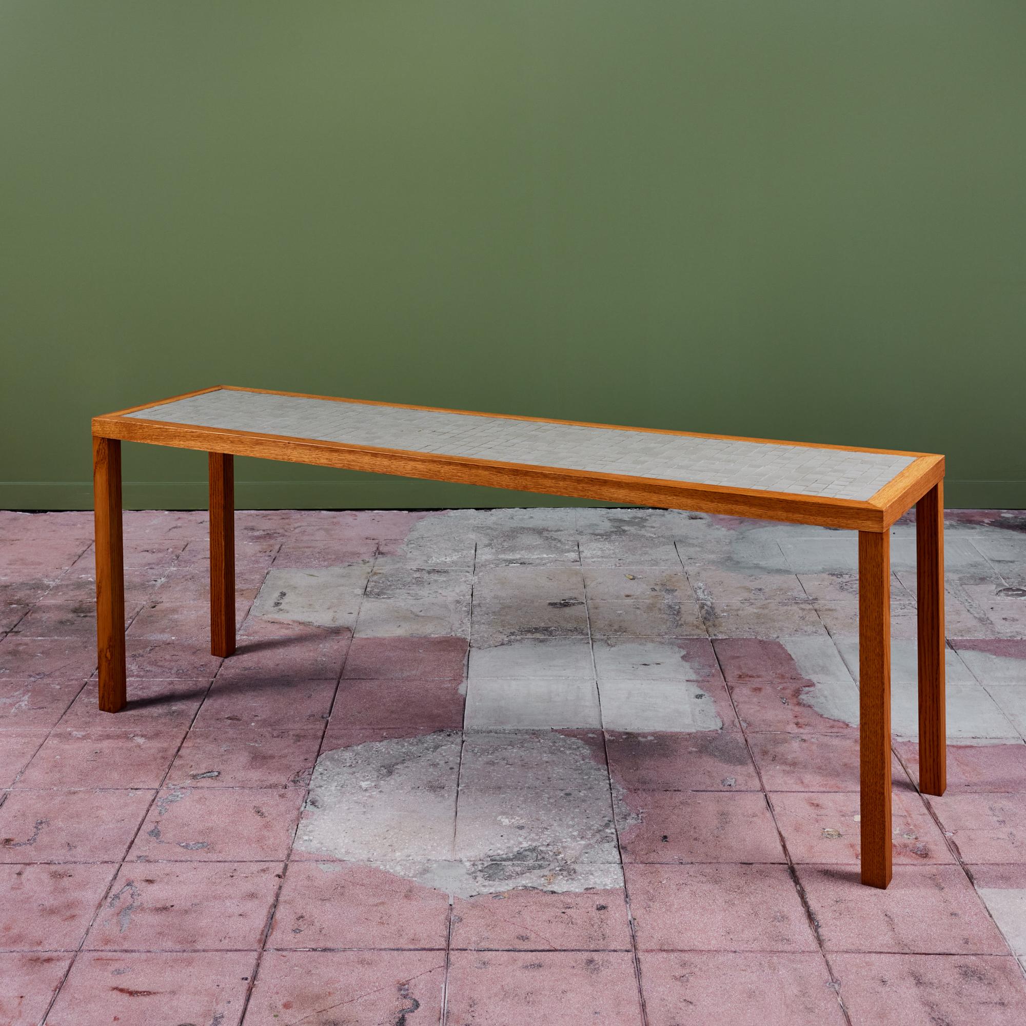 Console table by Gordon & Jane Martz. The table top is inlaid with square ceramic tiles in a speckled light gray. The frame of the table and four legs are solid oak.

Dimensions
72.25