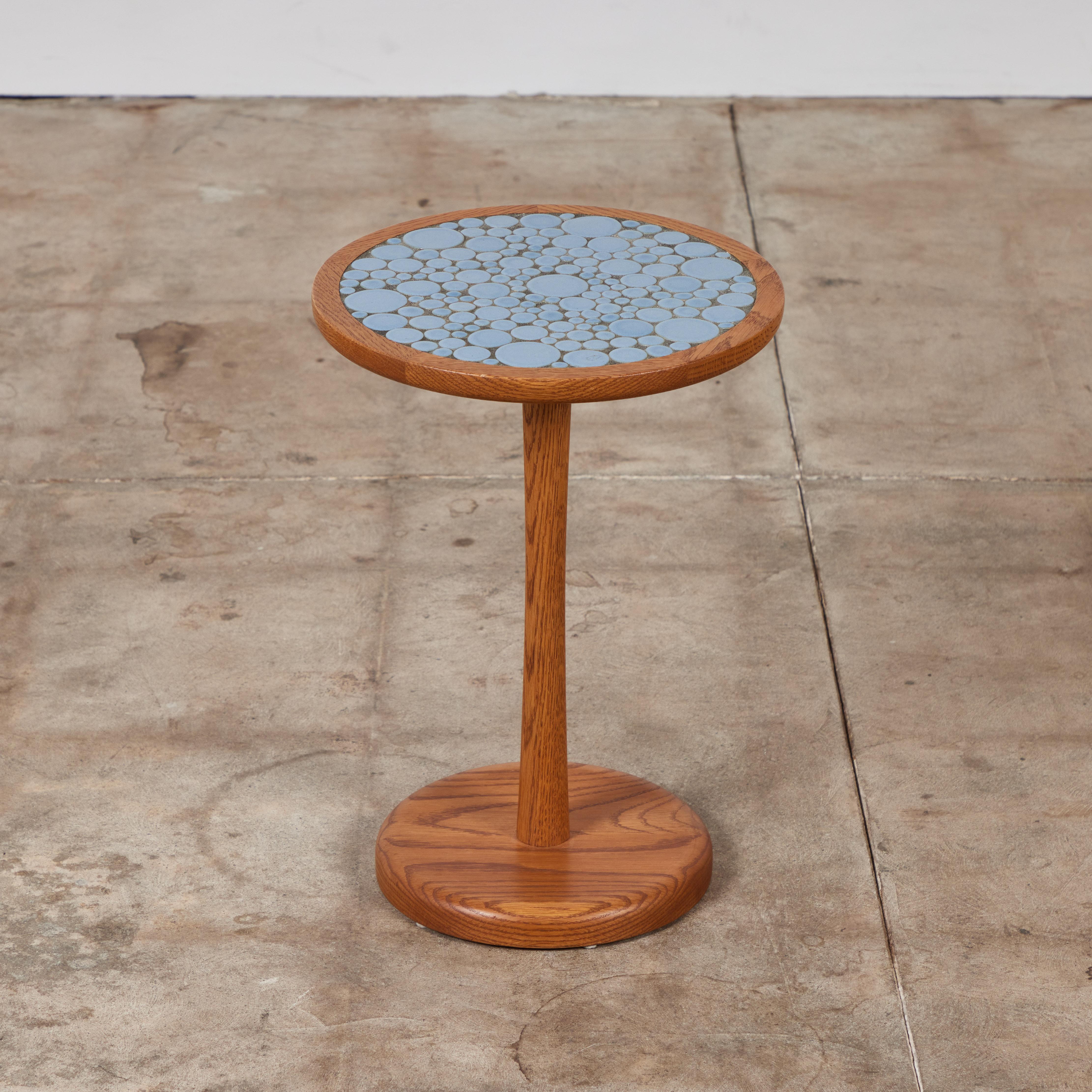 Round side table by Gordon & Jane Martz. The table top is inlaid with ceramic coin tiles in a soft  powder blue matte glaze. The frame, base and pedestal of the table are all solid walnut.

Dimensions
﻿13