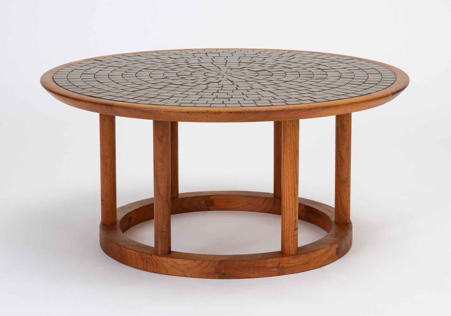 This round Gordon & Jane Martz occasional table has a mosaic top of sage and olive green square tiles in a sunburst formation, set into a solid walnut base. The top is supported by wooden legs rising from a smaller, round pedestal base. Versatile