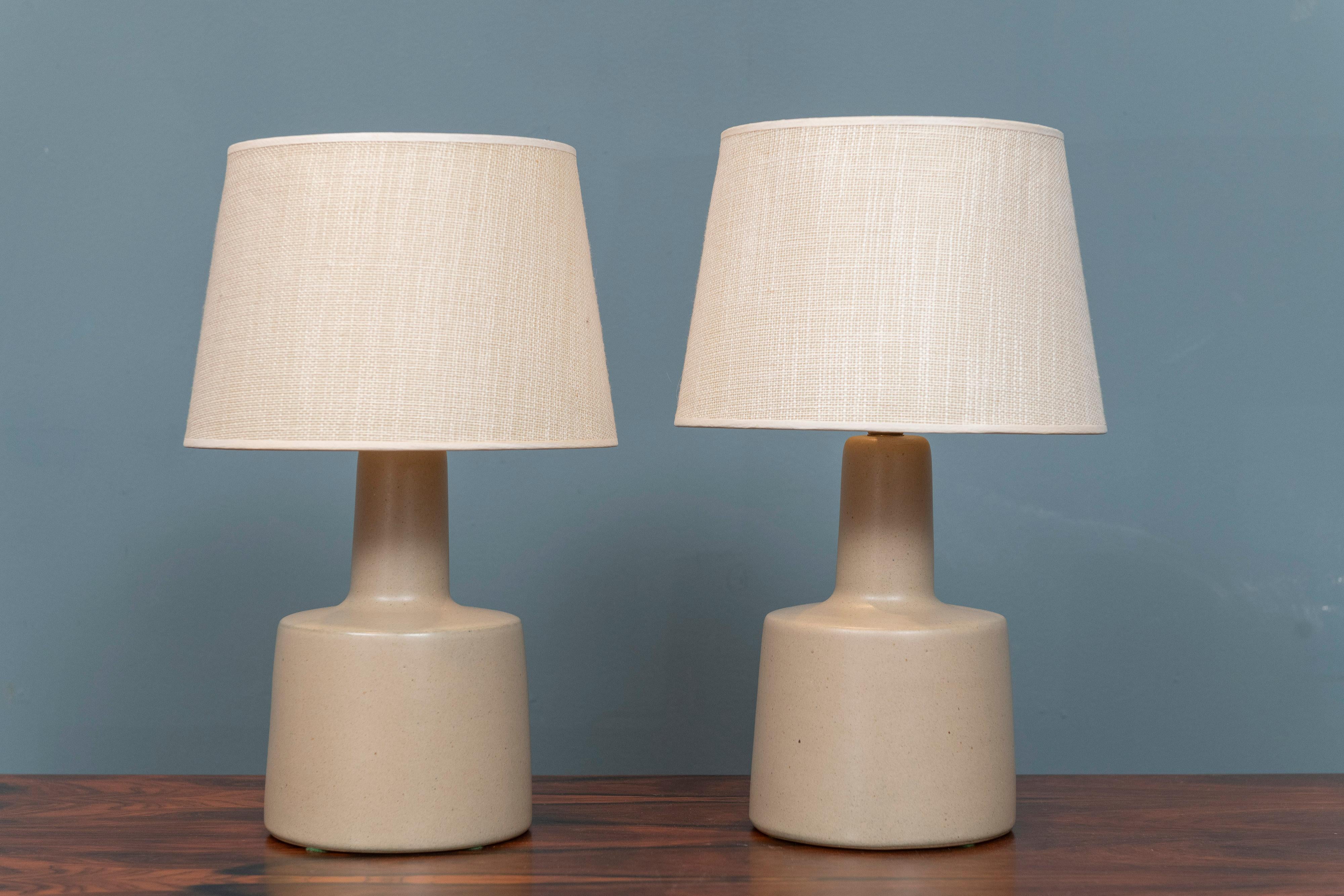 Gordon & Jane Martz design table lamps for Marshall Studios, U.S.A. Simple but modern design ceramic lamp bodies with vintage grass cloth shades that show age and wear but still present well. A sandy cocoa color that is smooth in texture and both