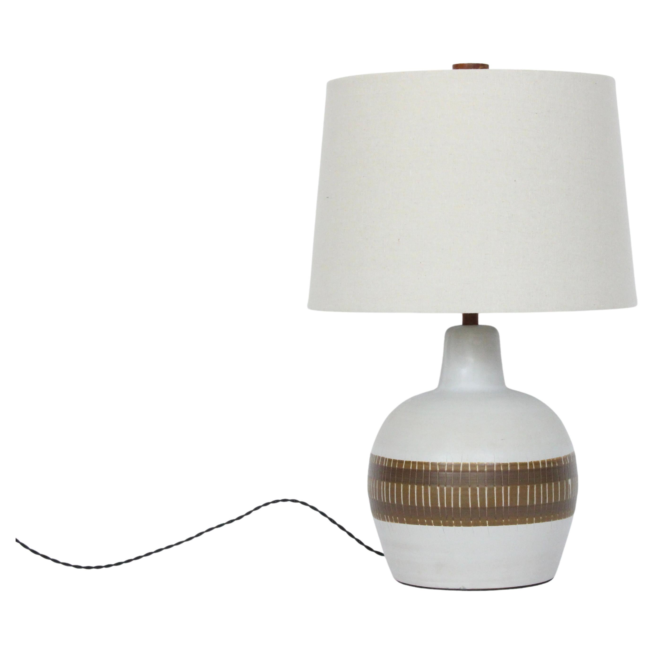 American Mid-Century Modern Gordon Martz M51 glazed stoneware table lamp. Featuring a classic handcrafted White M51 form, Walnut neck and finial, hand painted matte glazed two tone Coffee and Taupe banded design with incised detailing. Small