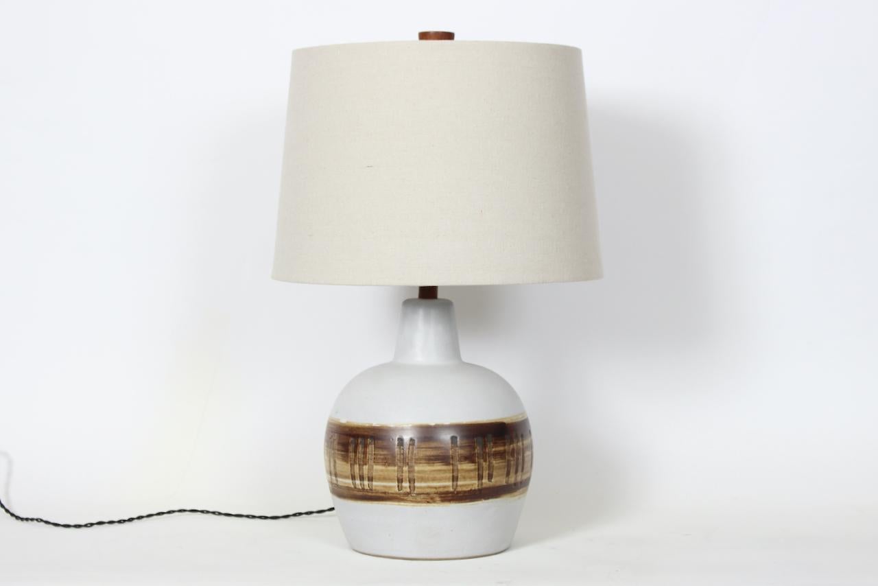 Gordon Martz M51 hand painted glazed Off White stoneware table lamp. Featuring a classic handcrafted White M51 glazed White Stoneware form, Walnut neck and original finial, hand painted in two tone Coffee and Cocoa glazed drip horizontal banded