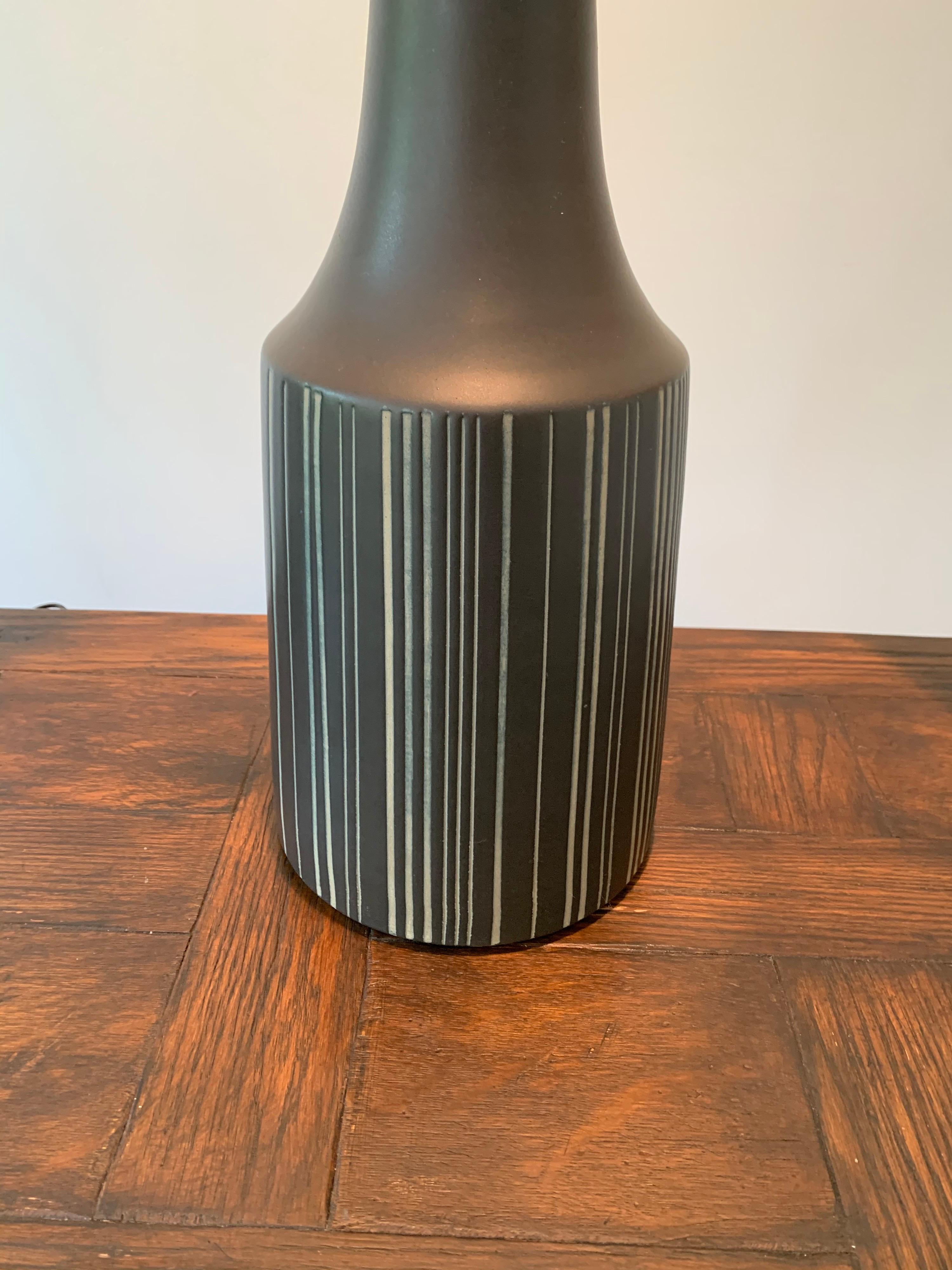 Pair of black sgraffito table lamps with walnut necks and finials. Slipcast, dipped in glaze, then hand painted with vertical lines. Signed and still have original labels.
Measures: Height to top of shade 36.5”.
