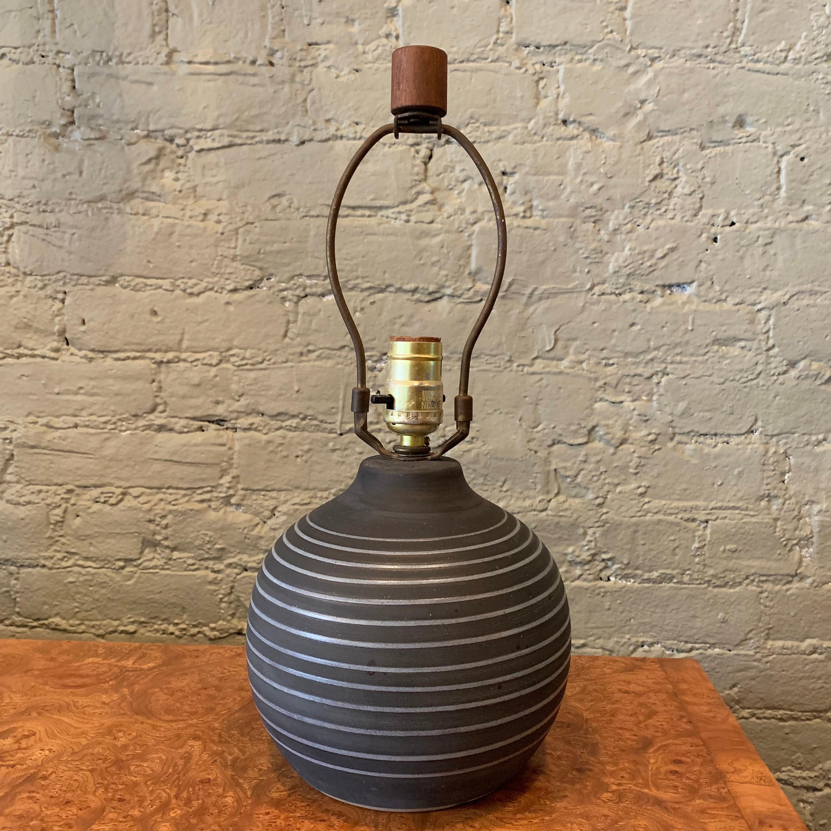 Mid-Century Modern, studio art pottery, table lamp by Gordon Martz for Marshall Studios features a charcoal gray, gourd shape body with swirl motif and walnut finial. The height of the lamp to the socket is 10 inches.